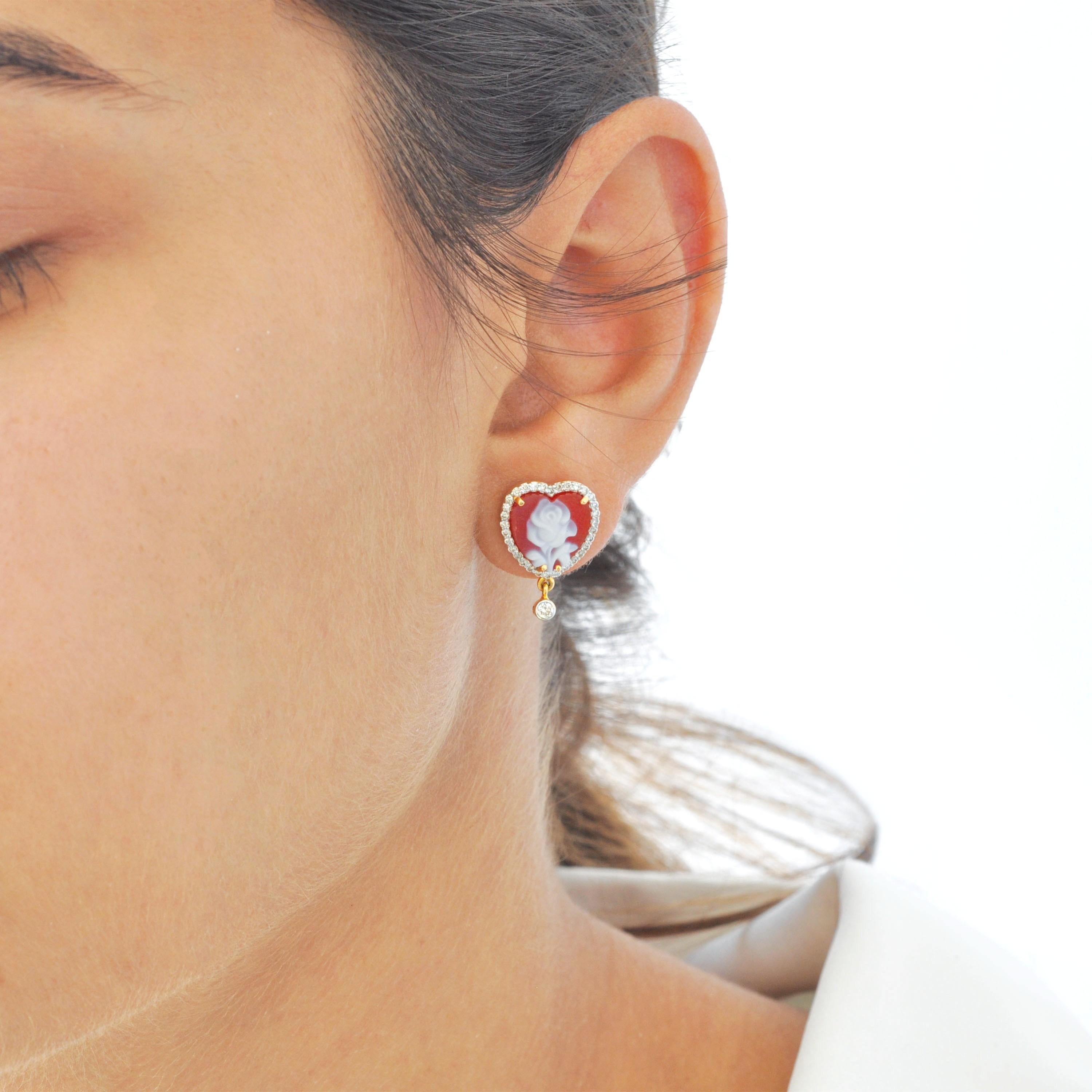 Diese 18-karätigen, rot-weißen, herzförmigen Kamee-Diamant-Tropfenohrringe strahlen zeitlose Eleganz, Romantik und handwerkliche Kunstfertigkeit aus. Jeder Ohrring besteht aus einer 10x10 mm großen, herzförmigen Kamee, die in aufwändiger Handarbeit