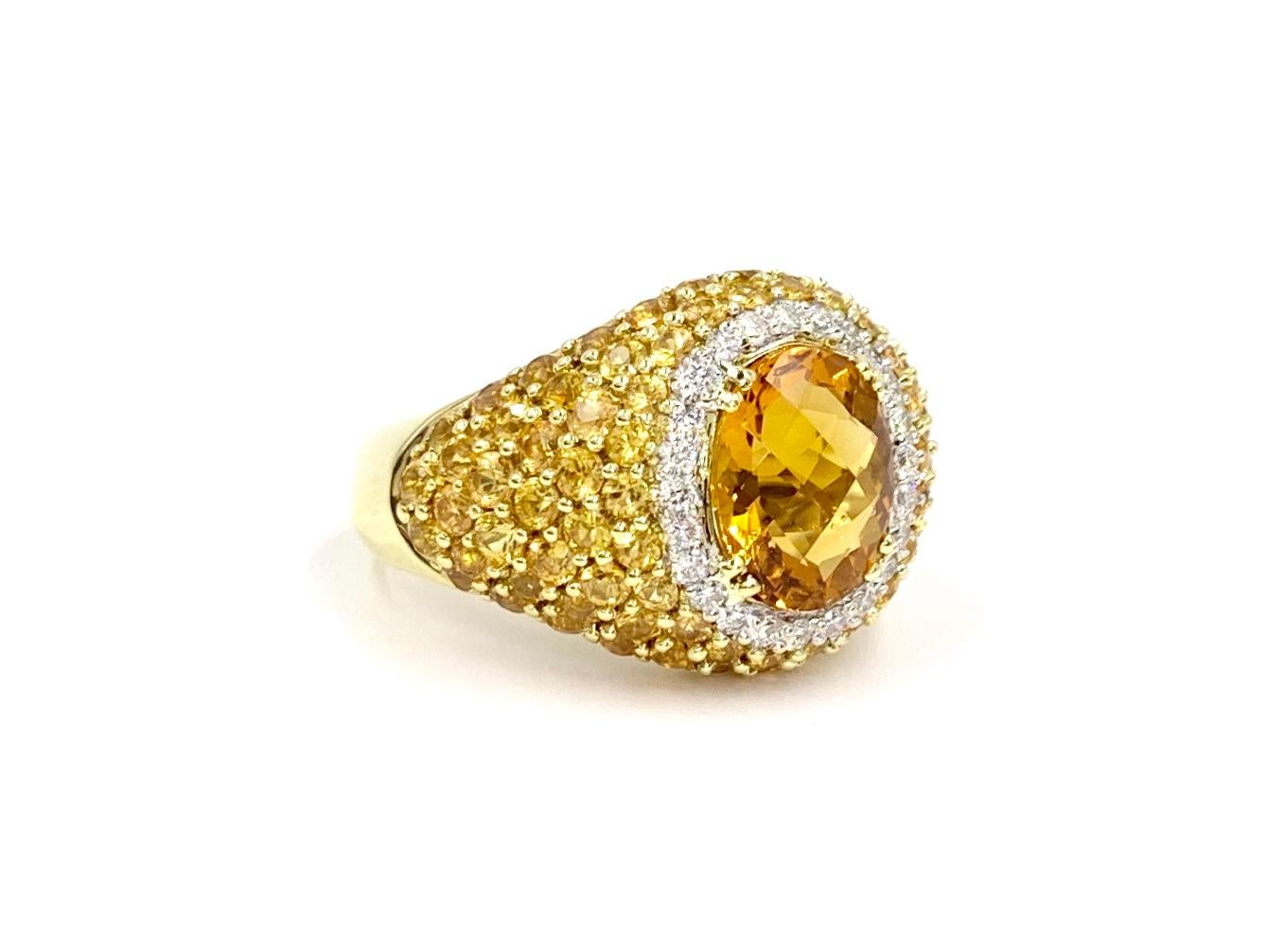 Fashionable 18 karat yellow gold wide ring featuring a 2.40 carat oval checkerboard faceted citrine surrounded by .28 carats of bright white diamonds and 2.75 carats of vivid yellow sapphires. Diamonds are approximately F color, VS2 clarity. Yellow
