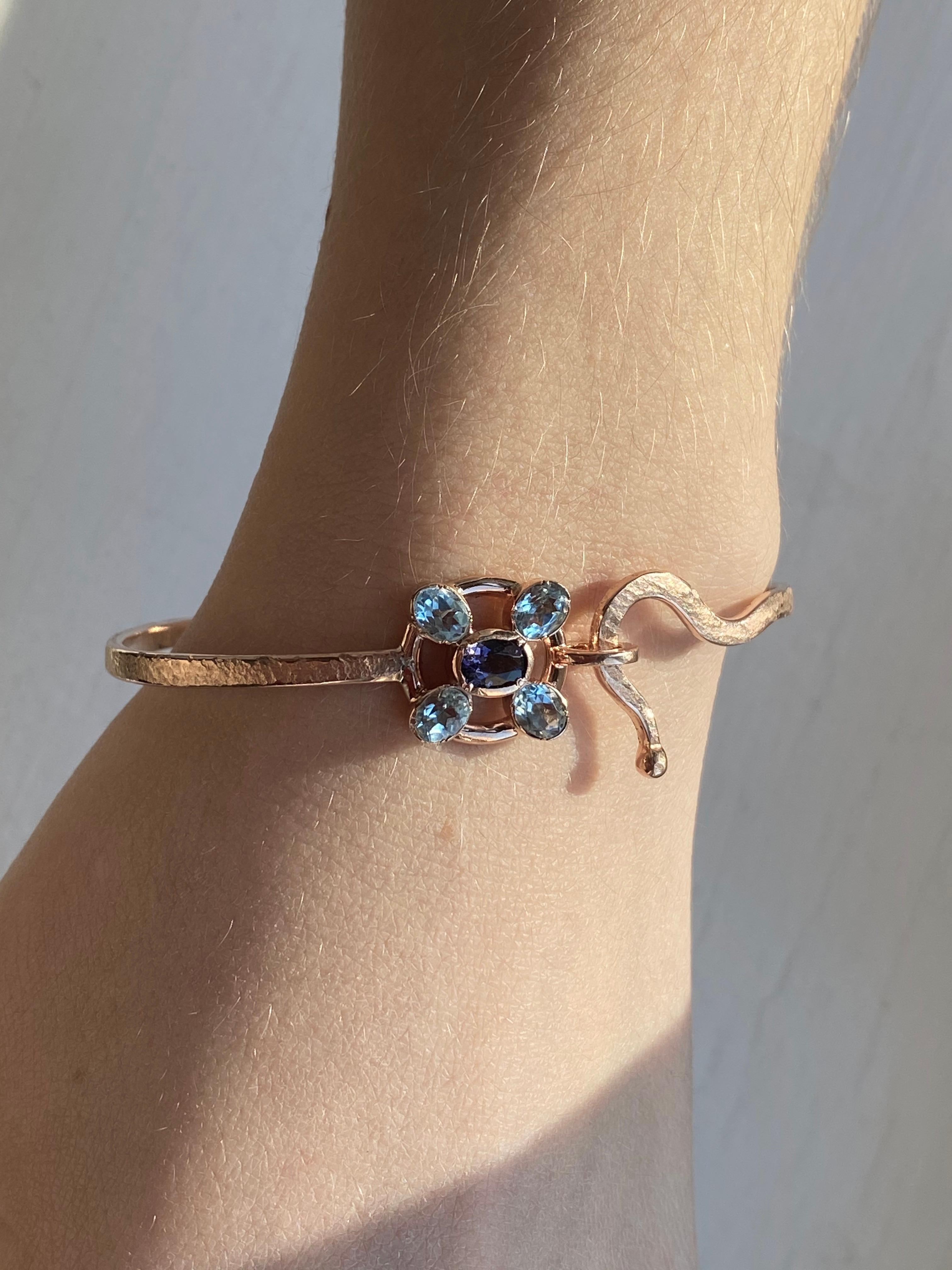 Introducing the exquisite Rossella Ugolini Design Collection, presenting a true masterpiece of jewelry craftsmanship - the handcrafted and hammered 18 Karats Rose Gold Aquamarine Blue Sapphires Bangle Modern Design Bracelet.  
Crafted with