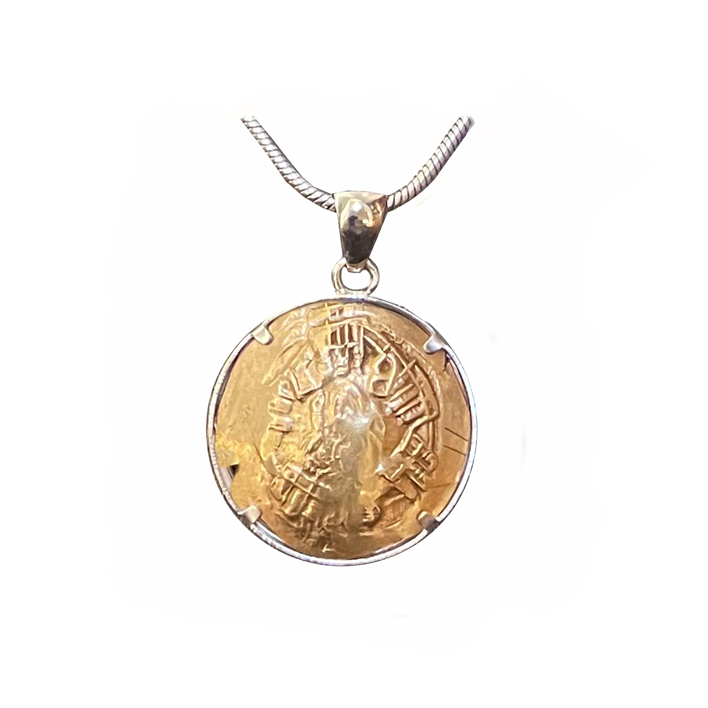 In this beautiful sterling silver pendant is set an authentic Byzantine 18 Kt gold coin ( 1295-1320 ) , depicting Andronicus II and Michael IX kneeling either side of Christ crowning both.
In the other side of the pendant there is the bust of the