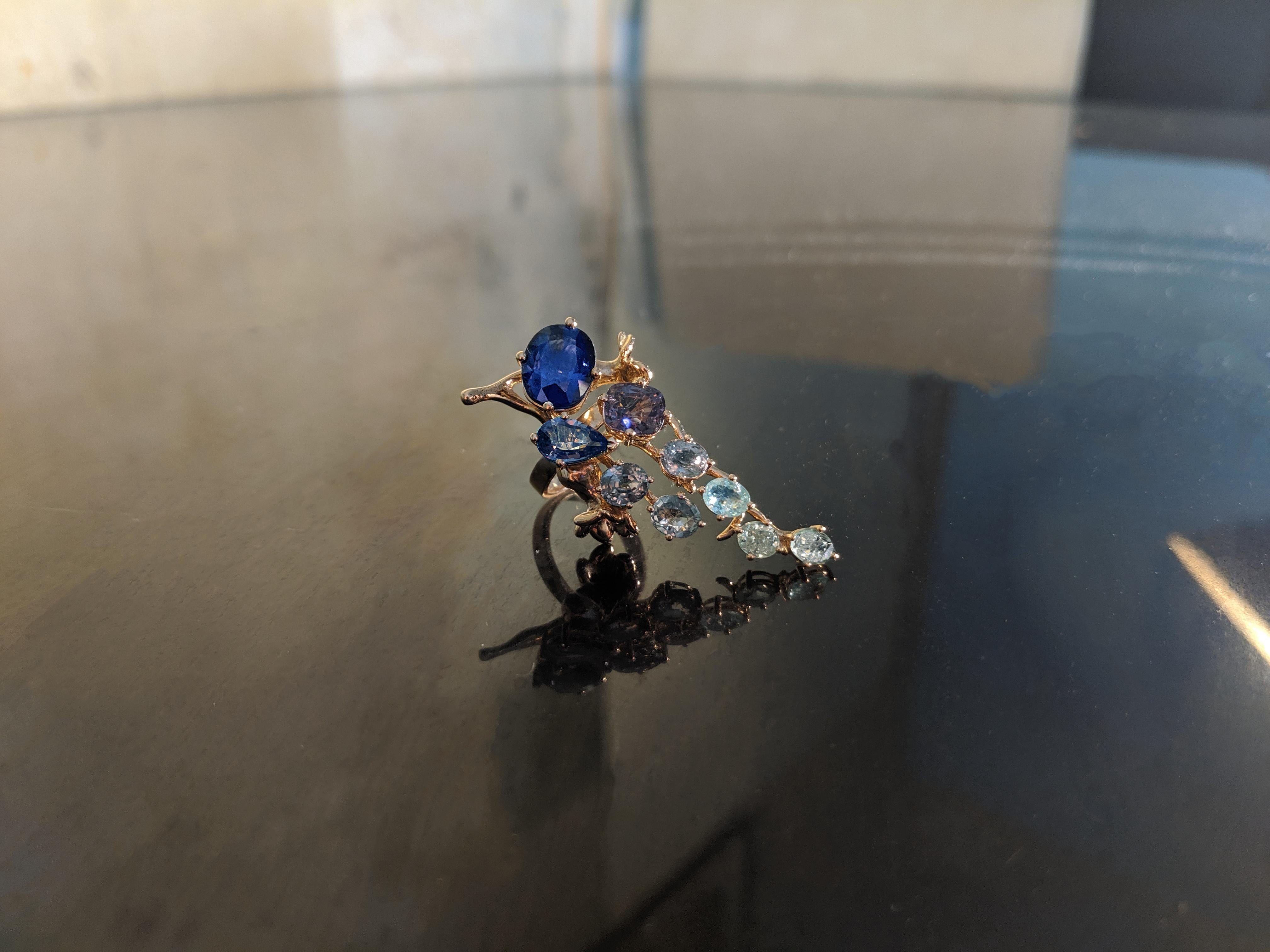 The center of this 18 karat yellow gold Tobacco Flower Engagement Ring is a GRS certified 5.23 carat vivid royal blue oval sapphire from Sri Lanka, a very precious gem that can only be set in such a delicate design. The dimensions of the sapphire