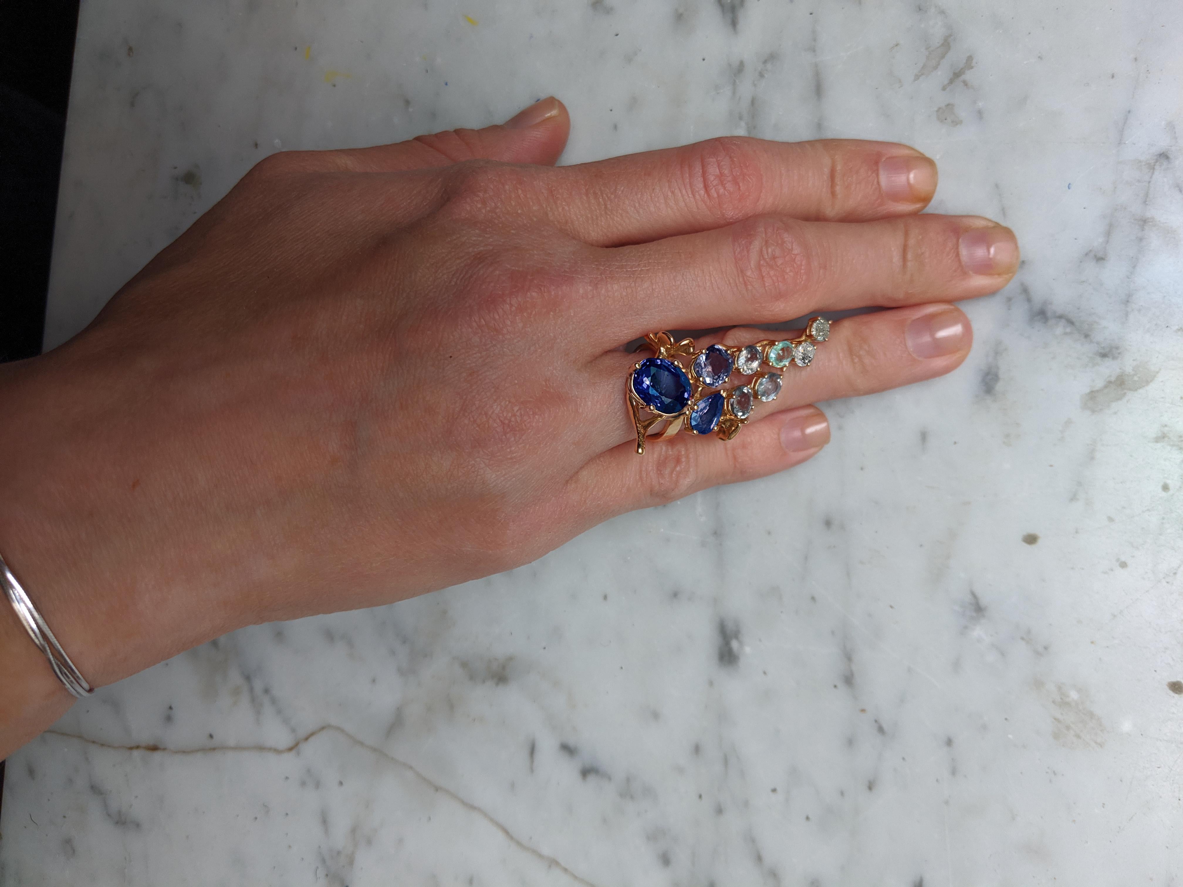 Tobacco Flower ring features a GRS certified vivid royal blue oval sapphire from Sri Lanka, which measures 10.73 x 9.64 x 5.99 mm and weighs 6.08 carats. The sapphire has not been heat treated. The ring is a work of art, designed by painter and 3D