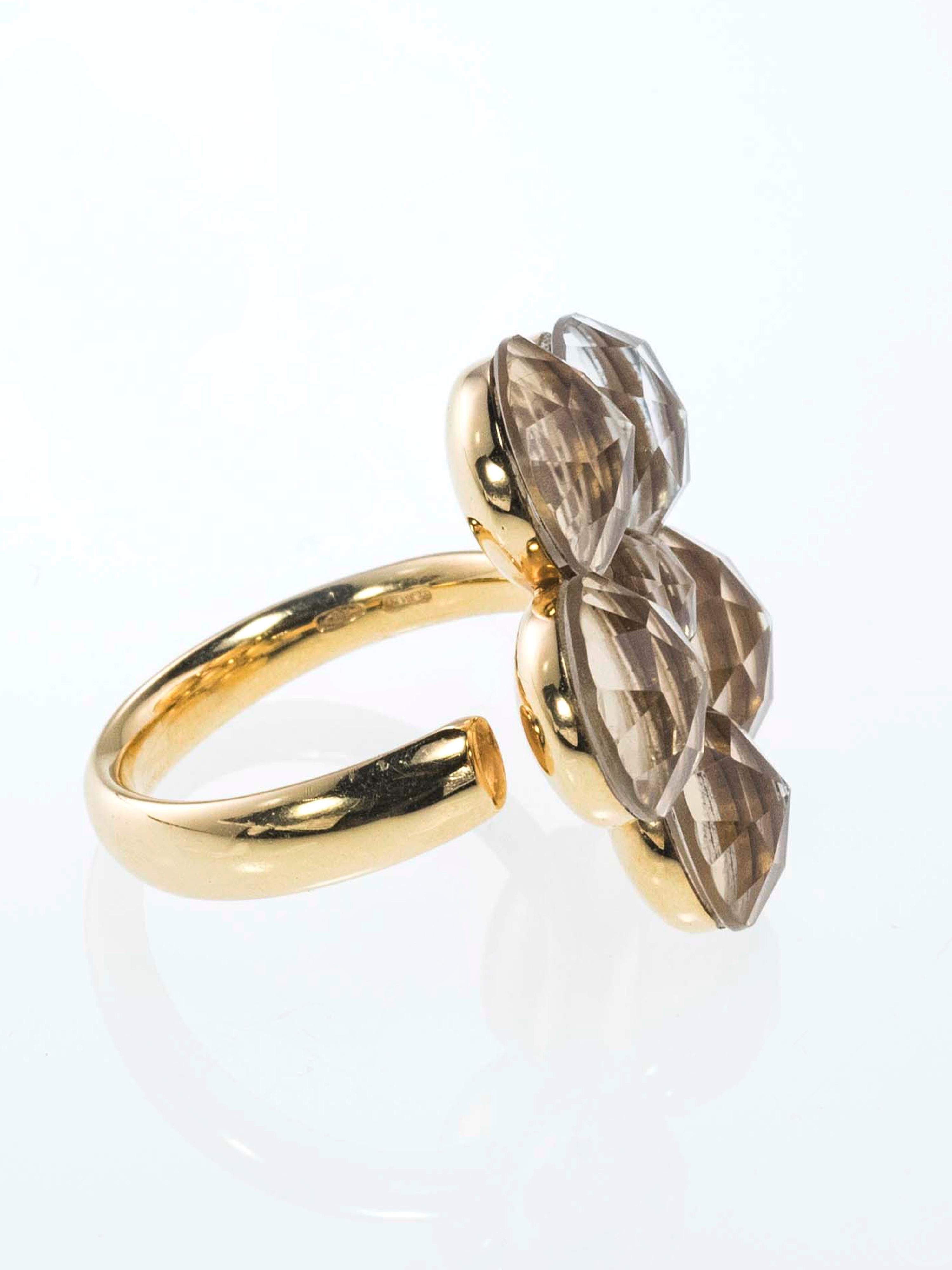 This ring has a very elegant and fanciful design. 
The mirroring gold below the stones gives brightness and luminosity to the faceted Rock Crystal and makes a beautiful lighting effect.
The lower part of the ring is designed as a flower stalk. This