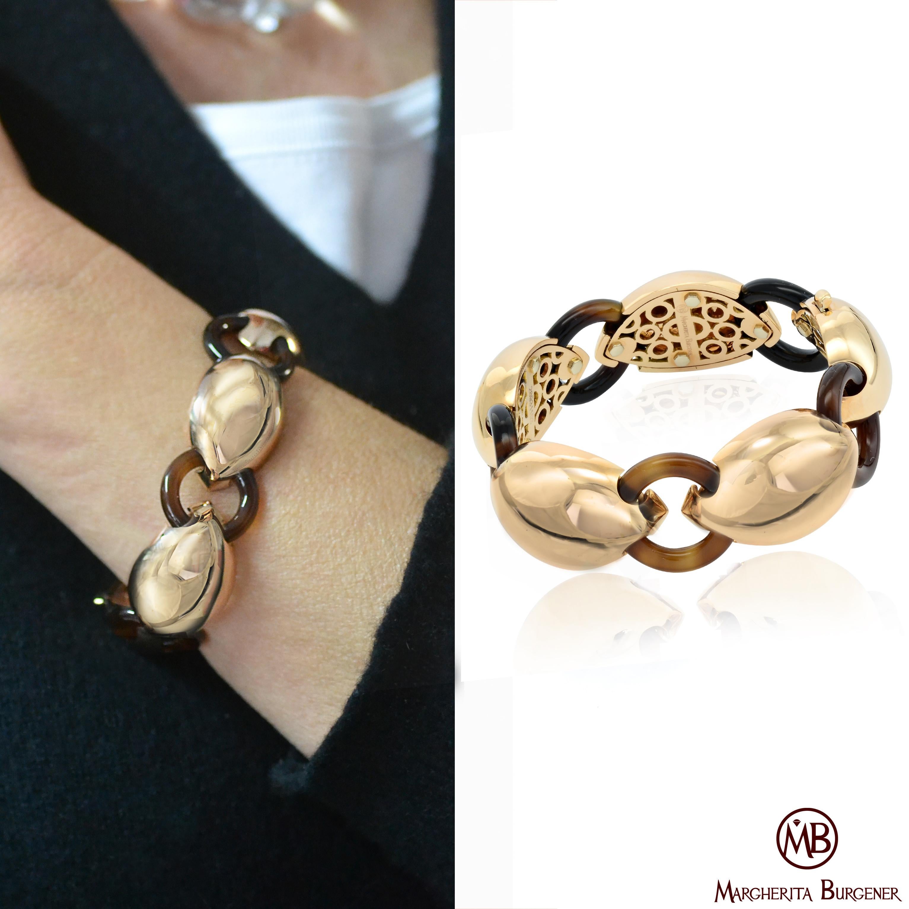 Fabriqué à la main en Italie, dans l'atelier de Margherita Burgener, le bracelet est composé d'une série de motifs bombés en or rose 18 KT poli, reliés par des ovales en agate brune naturelle.
La partie intérieure de chaque motif est joliment