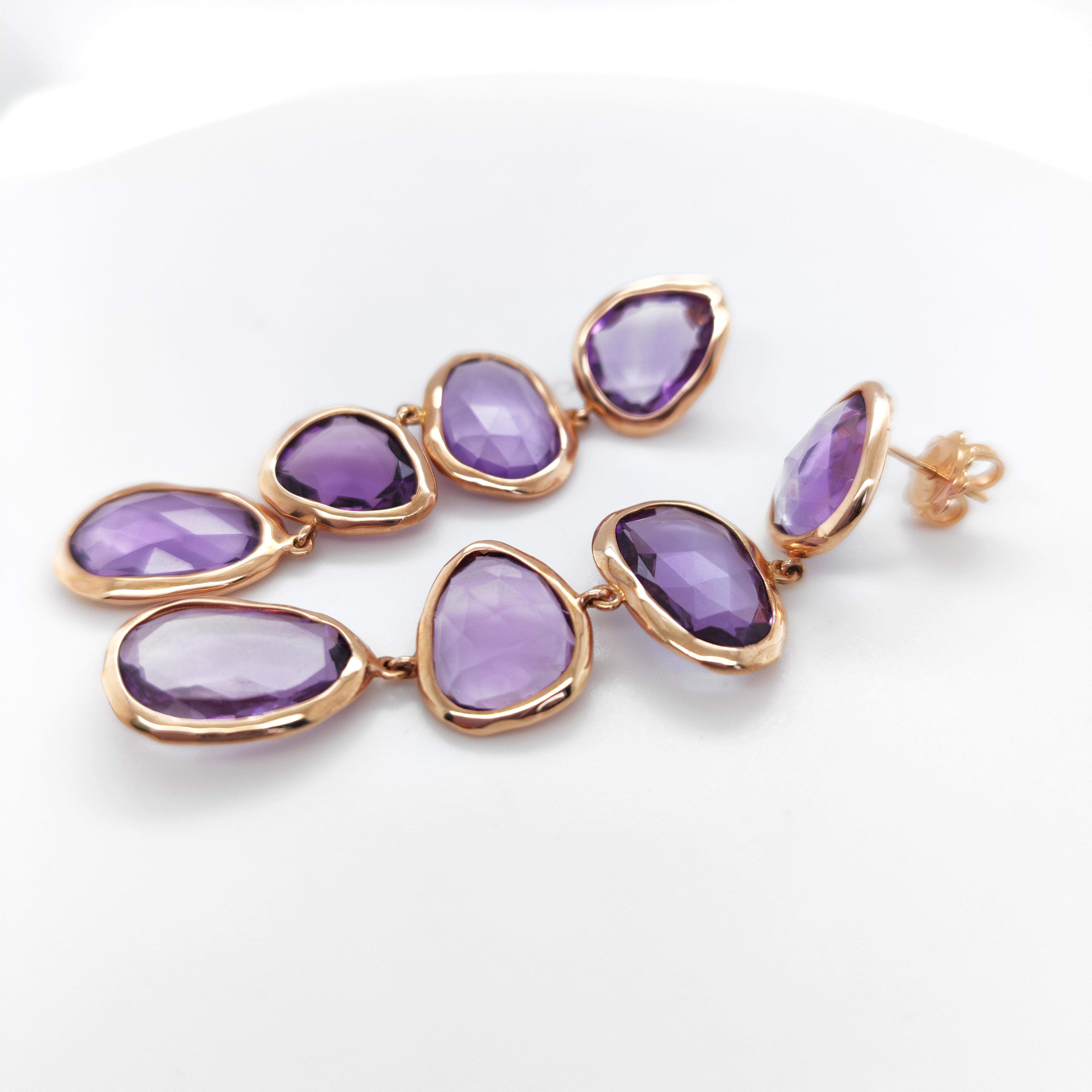 The Dharma collection takes inspiration from far away cultures reinterpreted in an occidental version. 
There is a game of fusion of natural stones, like amethyst in this earrings, featured in flat to mixed-cut stones. The co-presence of a faceted