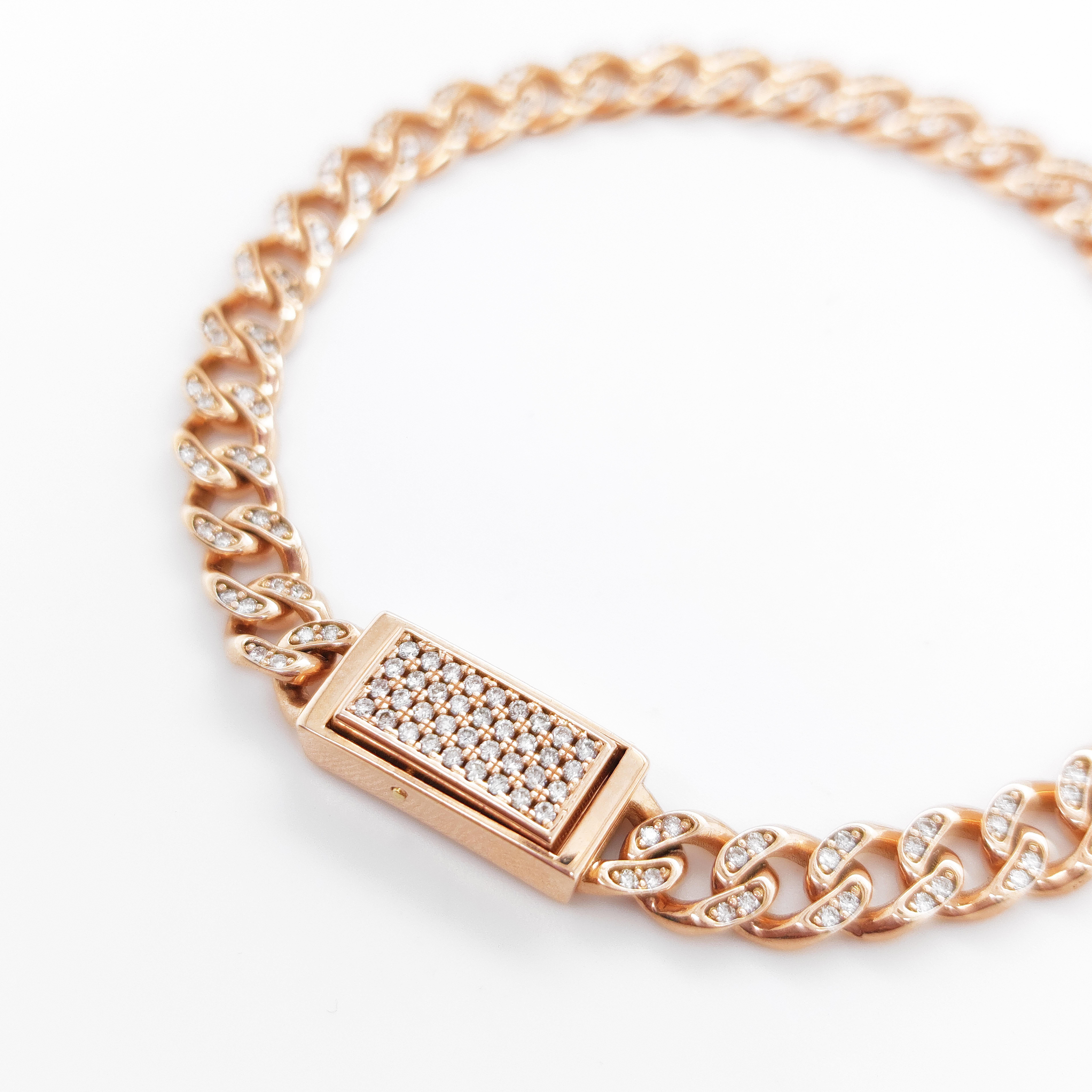 This bracelet is made from 18kt rose gold, giving it a warm and luxurious appearance. It features a Groumette style chain that adds a touch of modern sophistication. The bracelet is further enhanced with the addition of sparkling diamonds that are