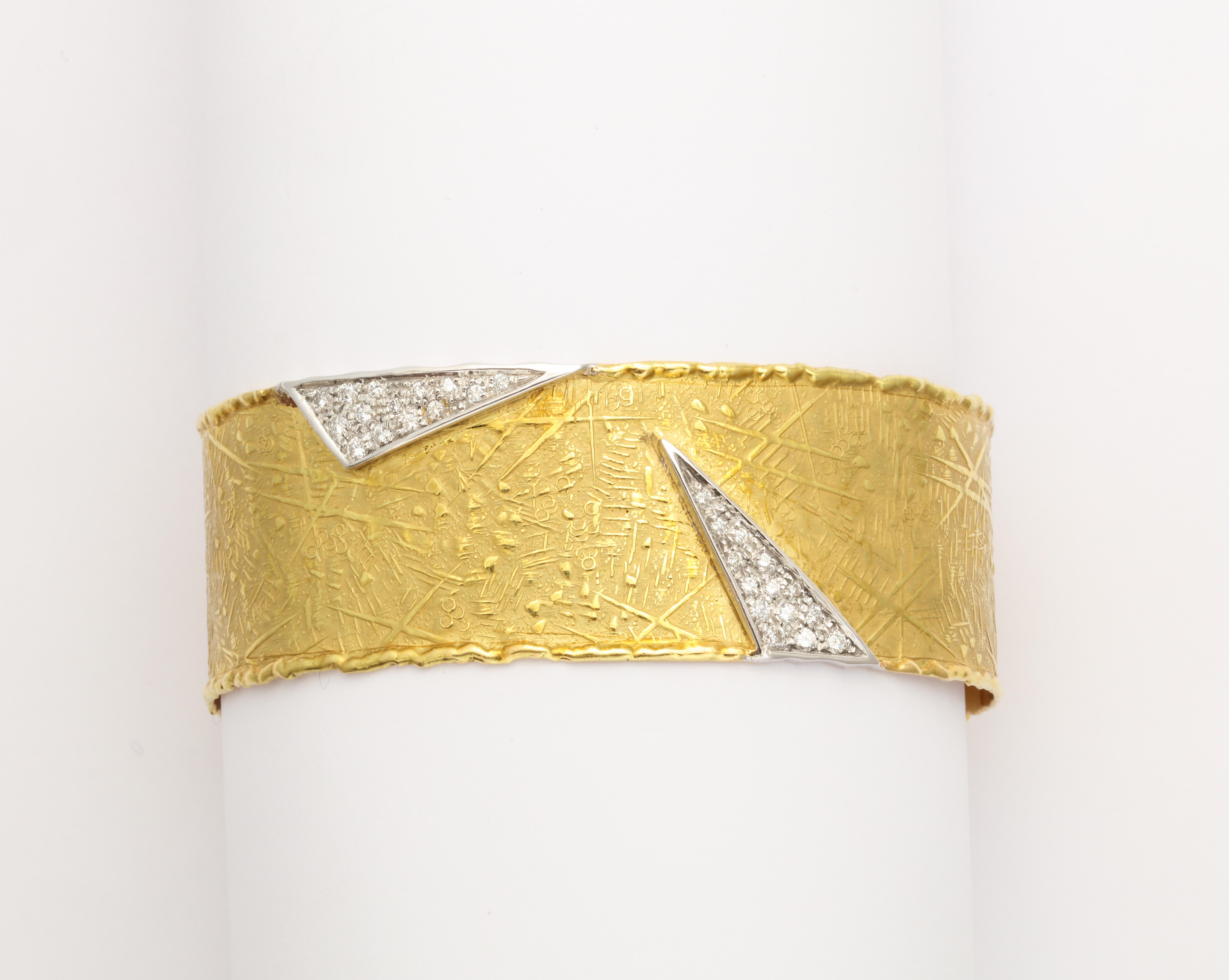 A elegant signed cuff by UnoARerre in 18 kt gold with triangles of pave diamonds and white gold