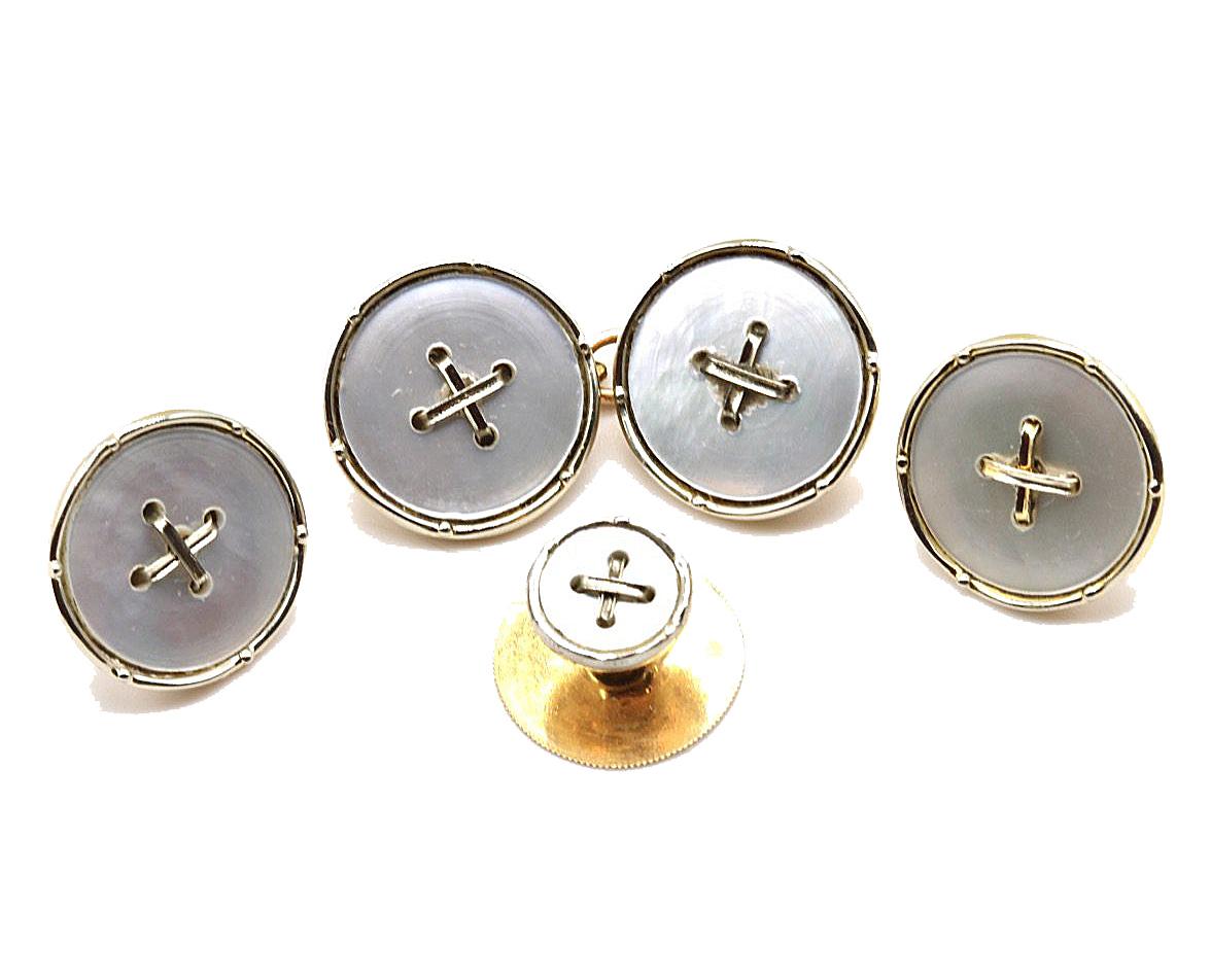 An 18 Kt white gold & 9 Kt yellow gold and Mother of pearl Gentleman's tuxedo cufflink and button dress set, comprising a pair of cufflinks, four buttons and two studs. The circular Mother of Pearl links with a central white gold cross edged in