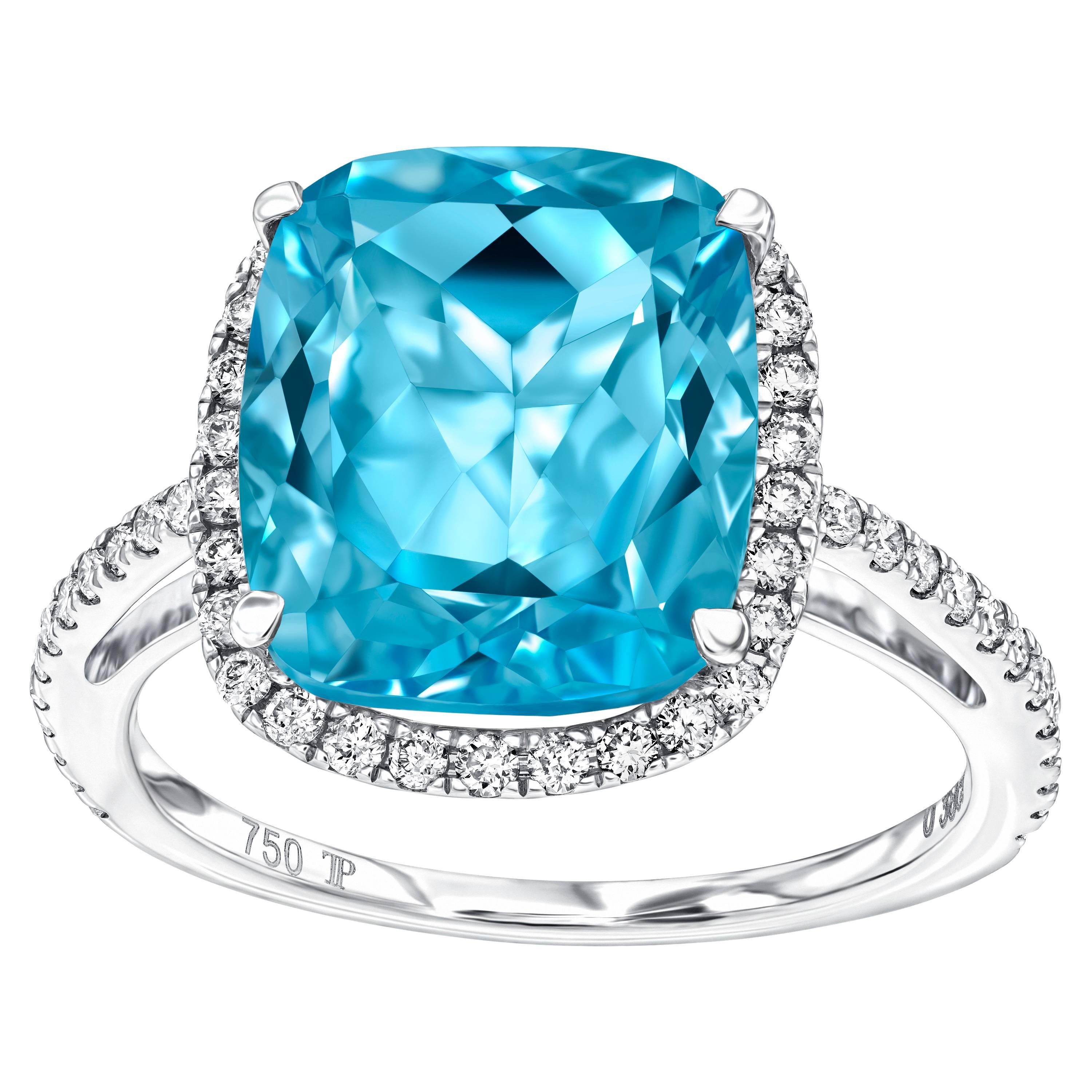 Questo eccezionale anello di fidanzamento con topazio blu taglio cuscino da 6,50 carati è circondato da un'aureola con diamanti tondi taglio brillante da 0,38 carati. 
Questo anello ha un peso totale di 6,40 - 6,88 carati, i diamanti sono bianchi e