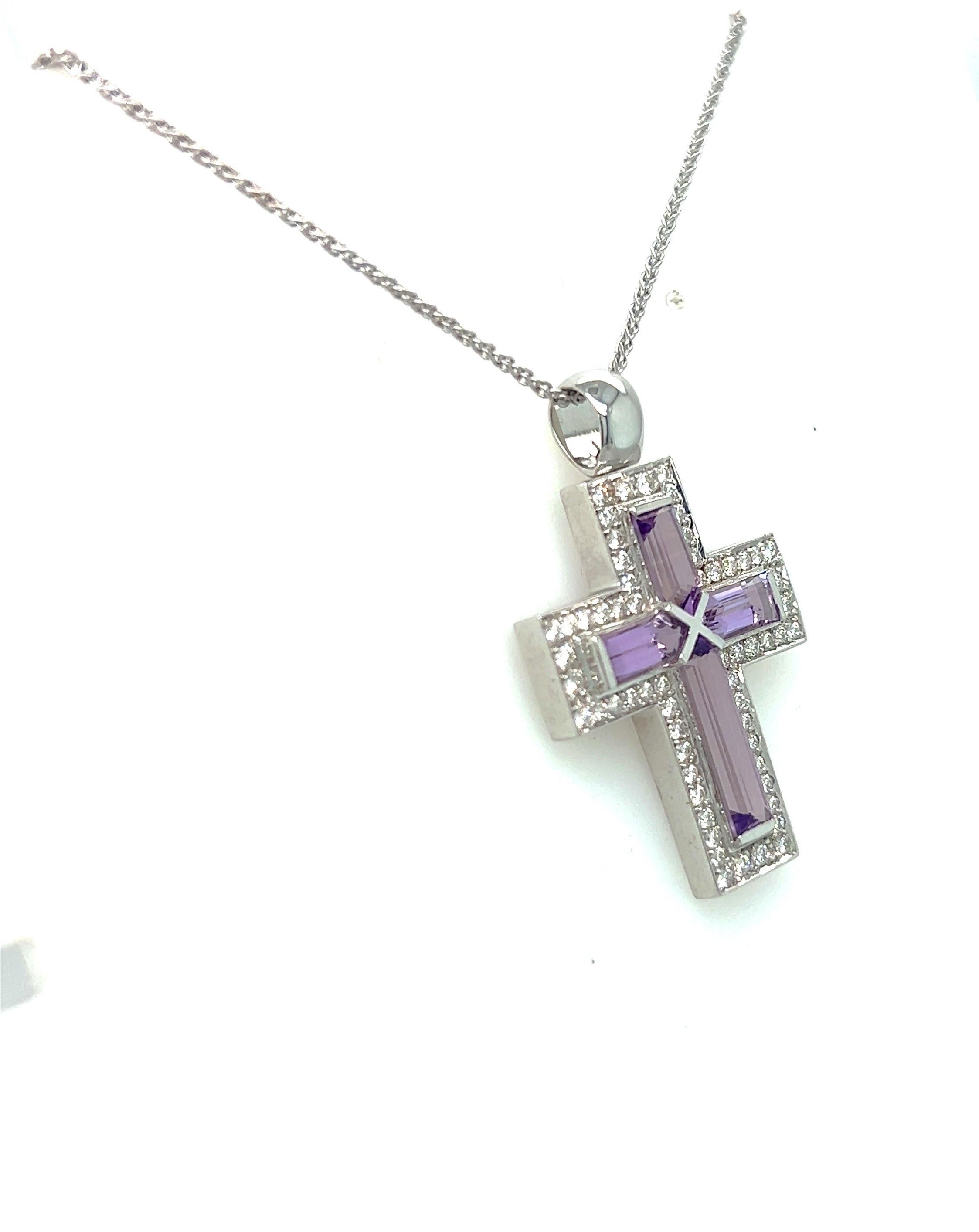 Beautiful 18 Karat white gold cross pendant necklace. The cross is beautifully set with 4 very long Amethyst Baguettes. Round Brilliant Diamonds border the Amethysts. The cross is 1-3/8