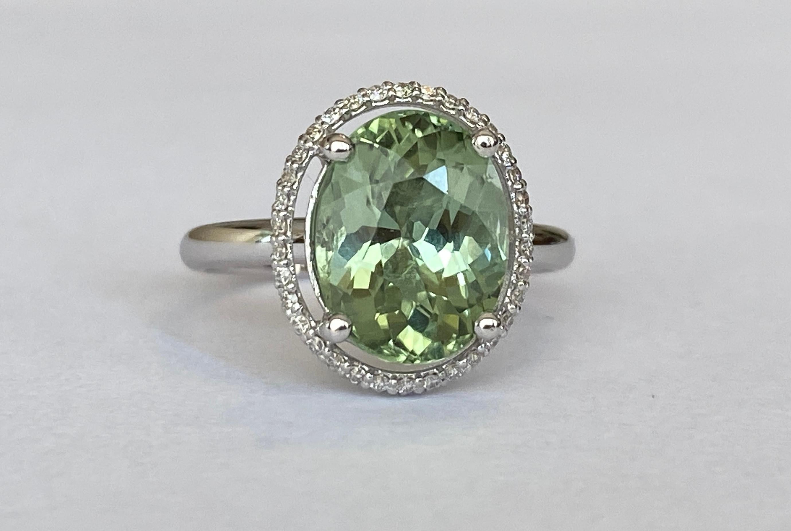 Offered beautiful ring in white gold, with a beautiful oval cut light green tourmaline 3.63 ct. The ring is decorated with 70 pieces of brilliant cut  diamonds, 0.45 ct in total, of quality G/VS/SI. 
Gold content: 18 KT hallmarked 
Cup size: approx.