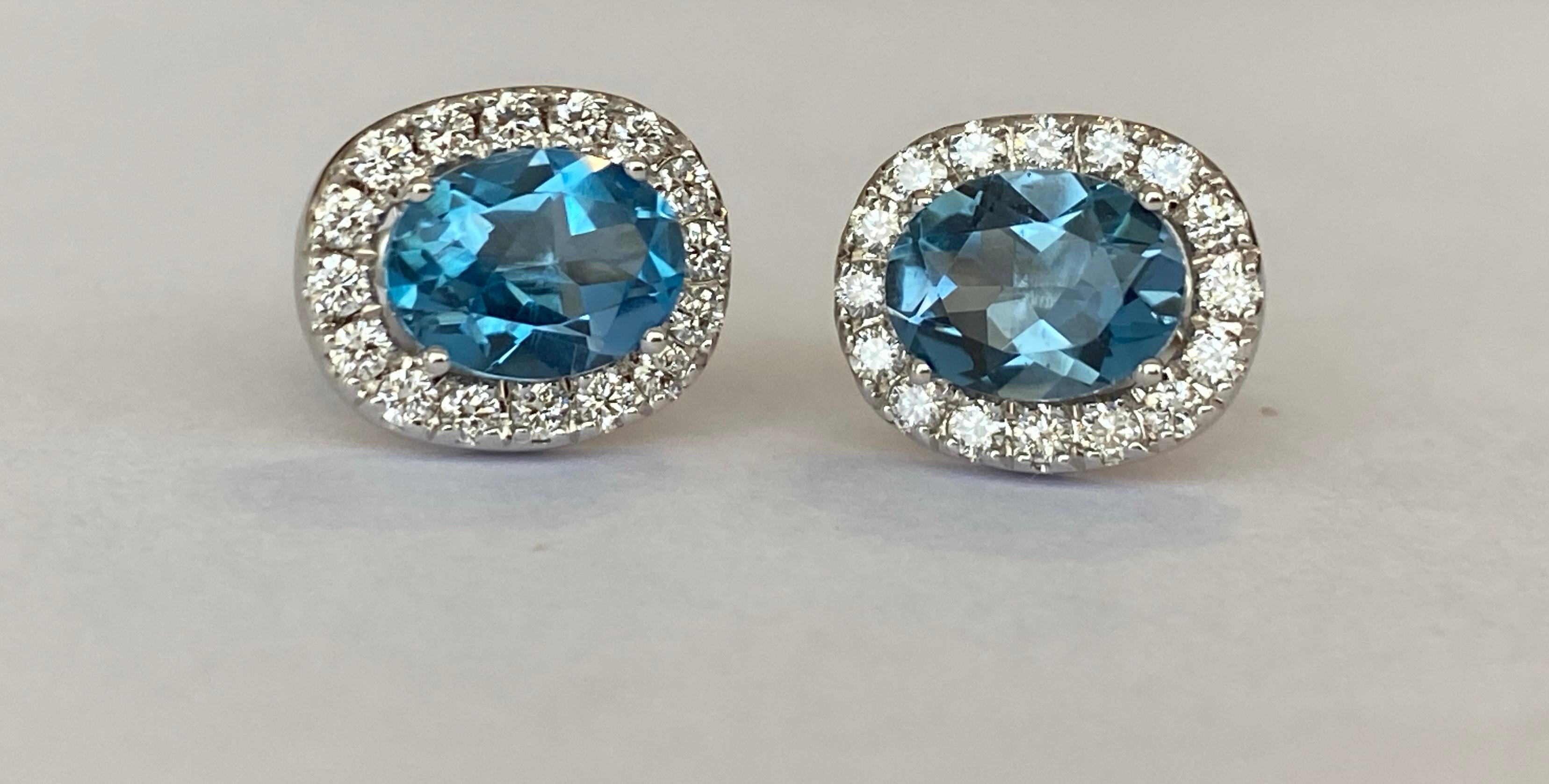 Offered in new condition, stud earrings in white gold, with two pieces of oval cut London Blue Topaz of approx. 2.6 carats together. The stones are surrounded by an entourage of 32 brilliant cut diamonds totaling approx. 0.58 ct of quality G/VS
Gold