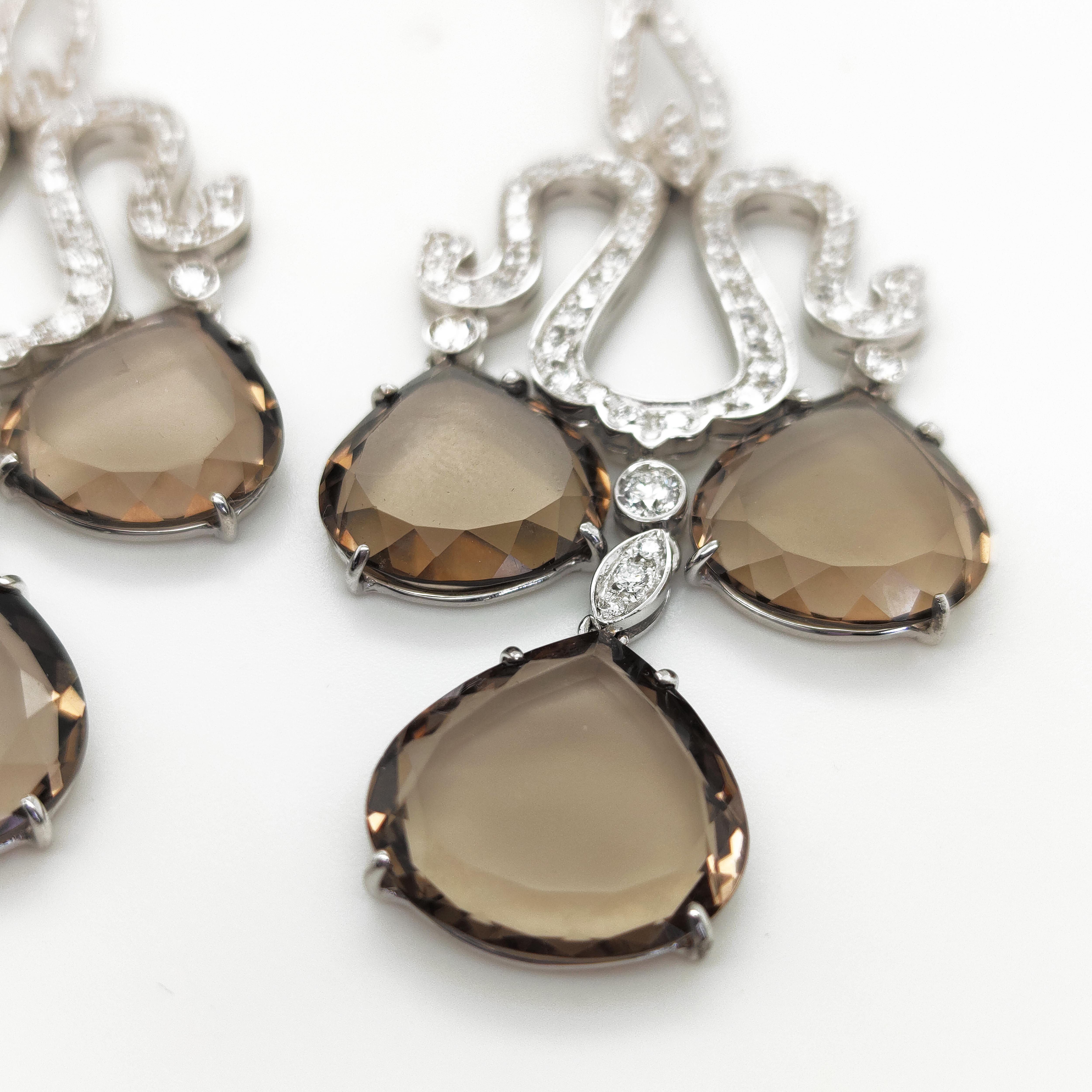 The chandelier style of these earrings creates a dramatic and impressive silhouette. They are sure to make a statement and add a touch of glamour to any outfit. The combination of smoky quartz and diamonds in white gold creates a stunning contrast