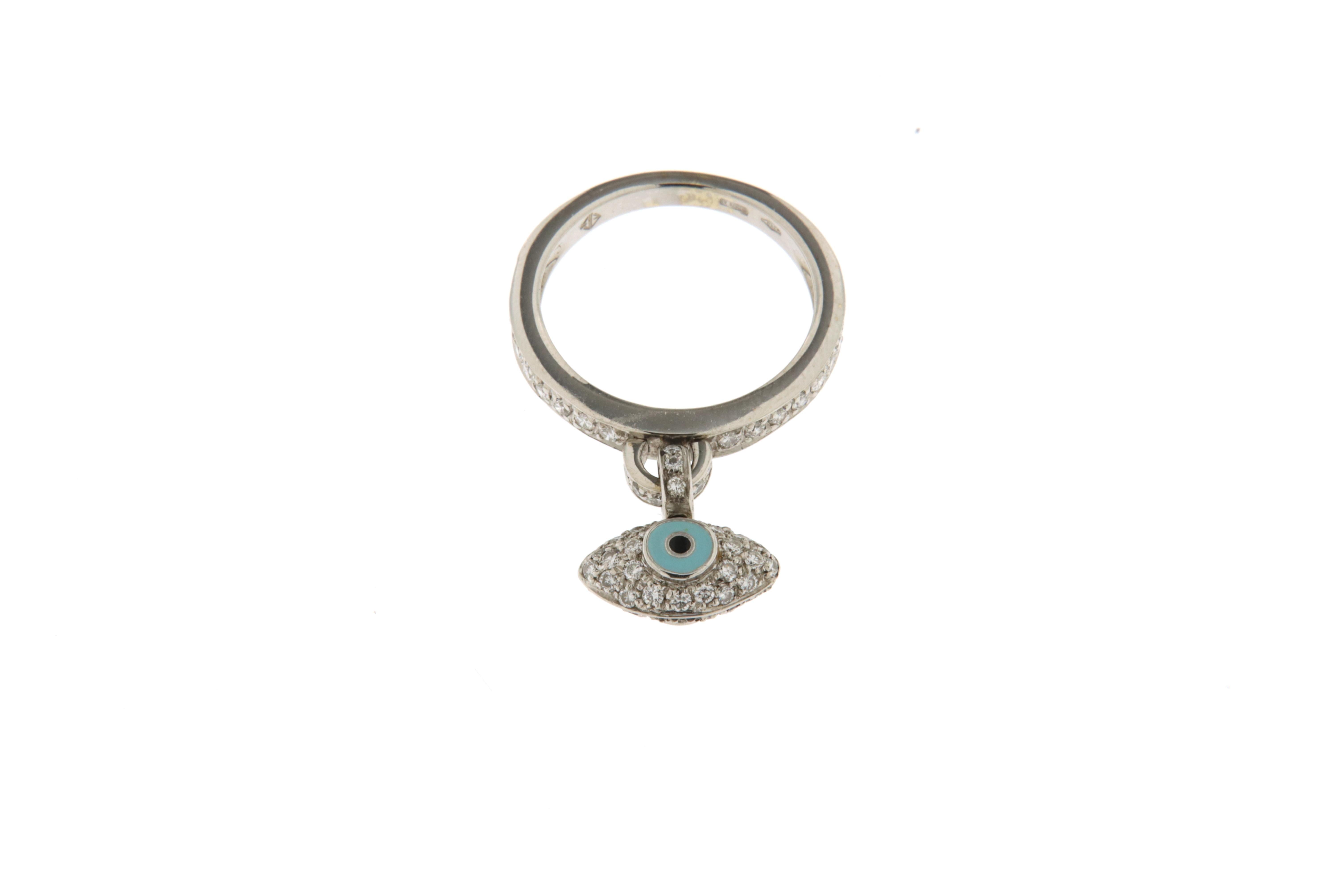 Eternity ring in white gold and diamonds (ct.0.39) with an eye of luck with diamonds and enamel. The eye is made with a diamond pave on both sides. The little eye is pendant in the center of the ring.