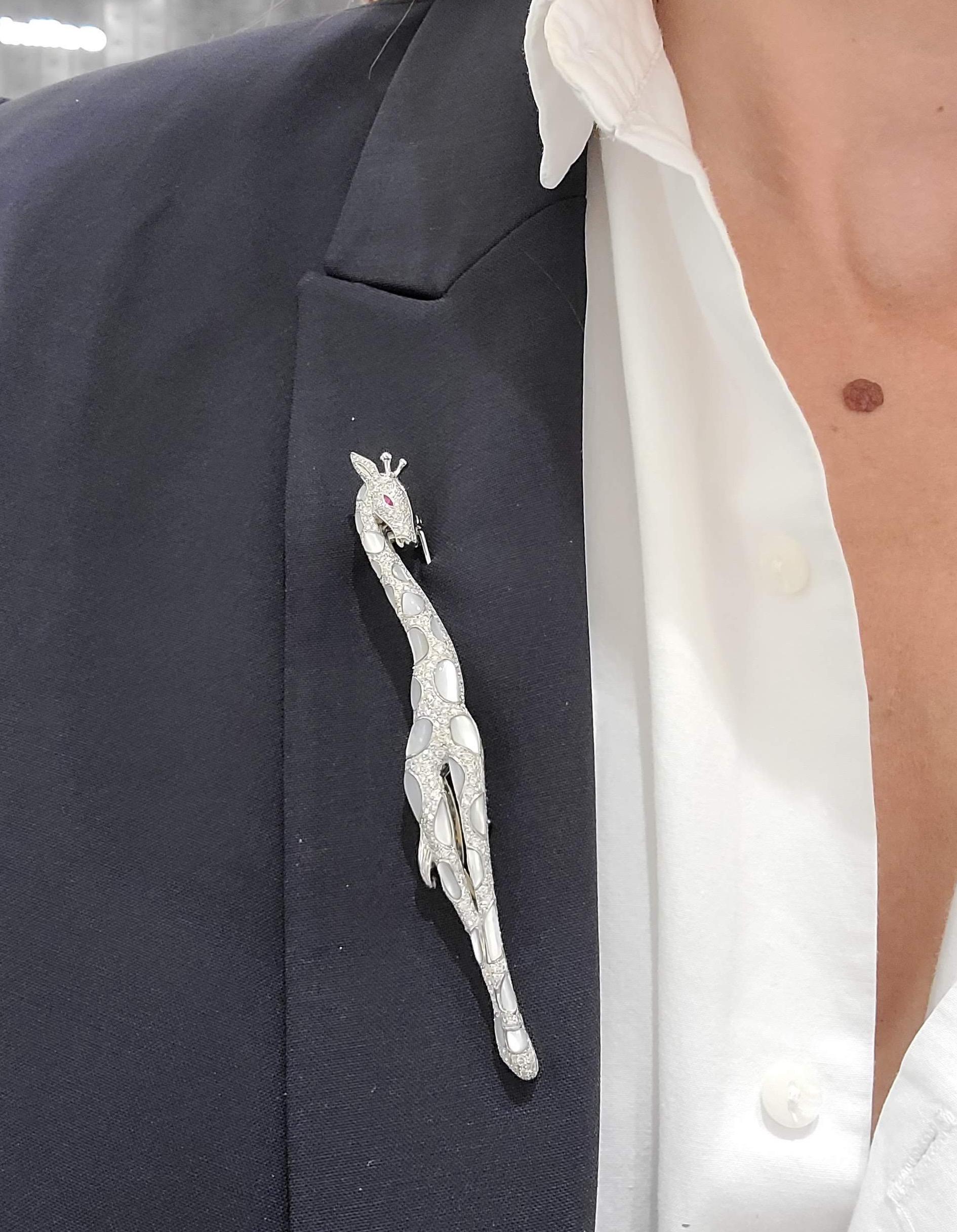 Este broche de oro blanco de 18 quilates con forma de jirafa real está engastado con pavé de diamantes y manchas de nácar blanco. Un único rubí marquesa está engastado para el ojo. Este broche mide 10 cm de largo.
Peso del diamante 3,30