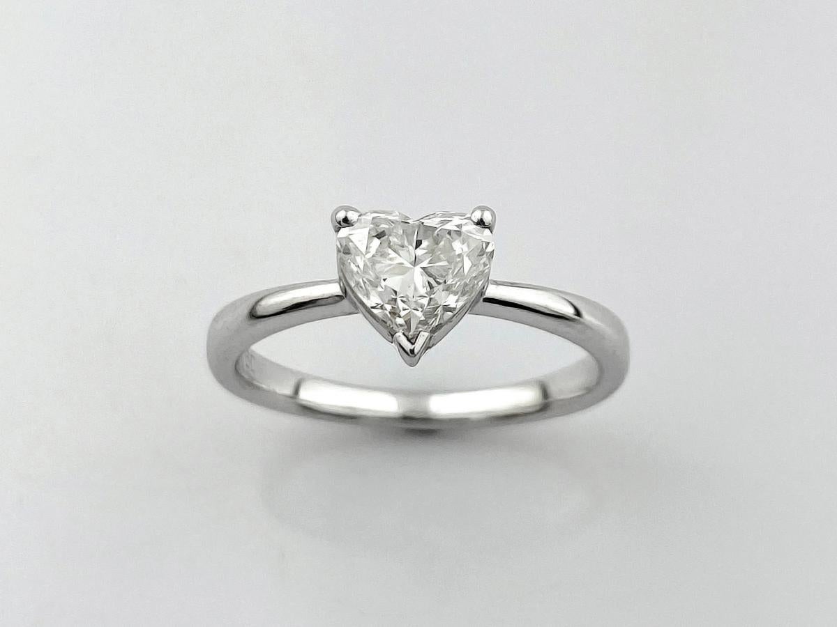 Dieser elegante Solitärring aus 18 KT-Weißgold ist mit einem atemberaubenden herzförmigen Naturdiamanten von 1,06 Karat besetzt, der Liebe und Hingabe symbolisiert. Das schlichte und minimalistische Band hebt die Brillanz des mittleren Diamanten