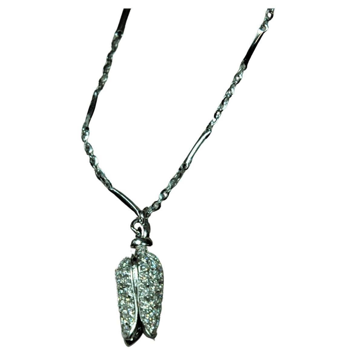 Collana in oro bianco 18 kt con pendente a forma di bocciolo, interamente ricoperto di diamanti taglio brillante (ct.1,02). La catena alterna barre lucide con un piccolo diamante rollò. La manifattura italiana manifesta tutta la sua bellezza e
