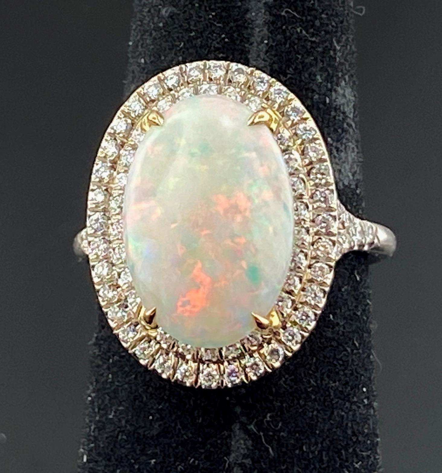 Set in 18 karat white gold is 15 x 11 mm oval Opal surrounded with 82 round brilliant cut diamonds in a two row frame with a total diamond weight of 0.60 carats.  Ring size is 6.25.