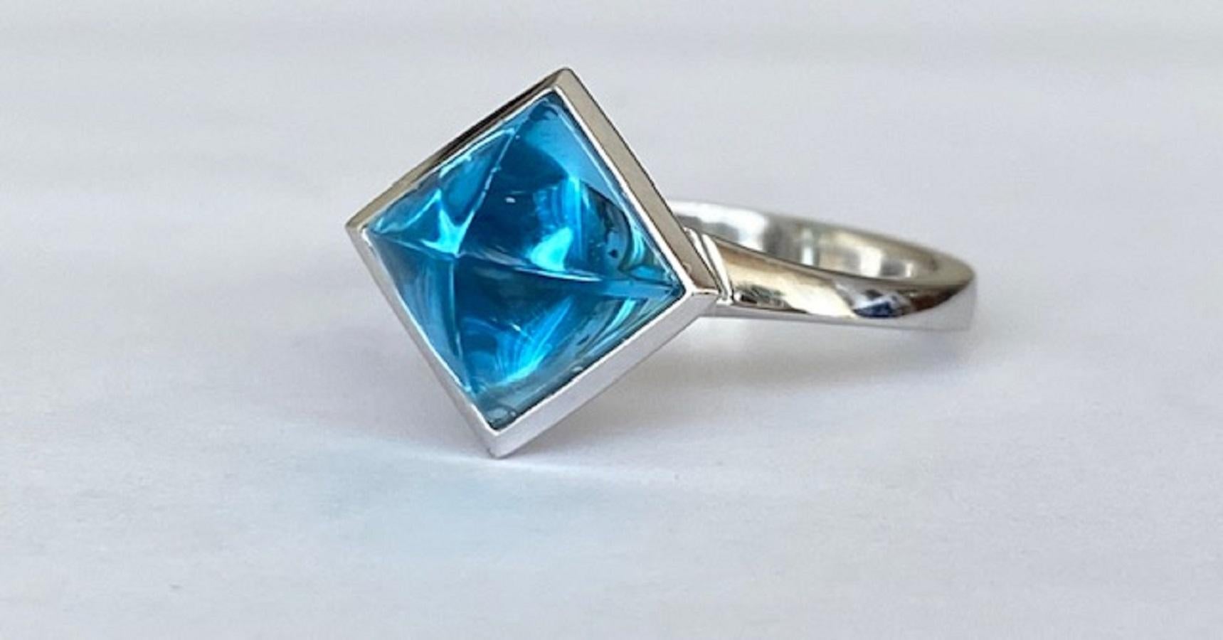 Offered in excellent condition is a designer ring in 18 kt white gold, with a fantasy cabochon cut topaz approx. 3.00 ct, surrounded by an entourage of 39 brilliant cut diamonds. Total diamonds: approx. 0.39 ct G/VS.

Gold grade: 18 KT (marked)
1