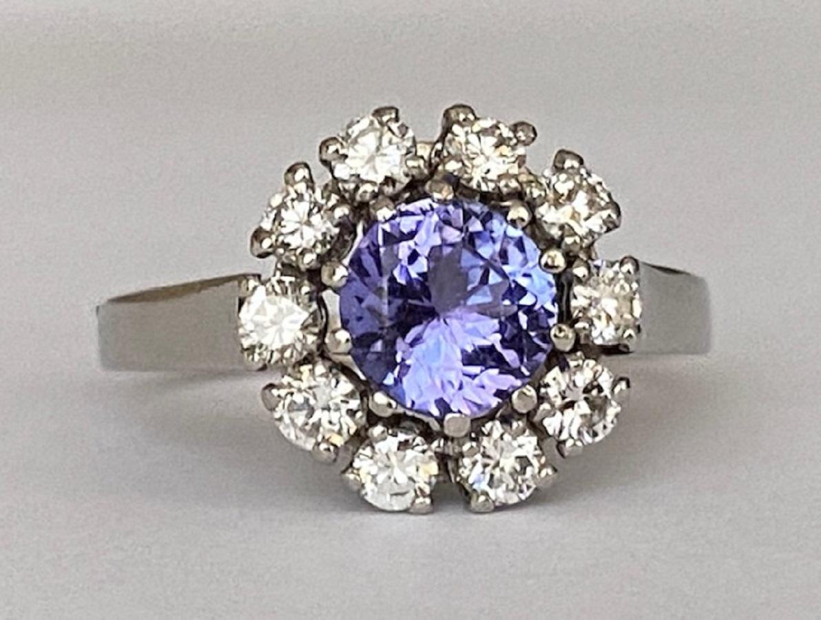 Offered in good condition is a white gold 18 carat rosette ring, in the middle a round cut tanzanite of approx. 0.90 ct, surrounded by 10 pieces of brilliant cut diamonds totaling approx. 0.60 ct of quality G/VS.
Content: 750 (tested)
Natural