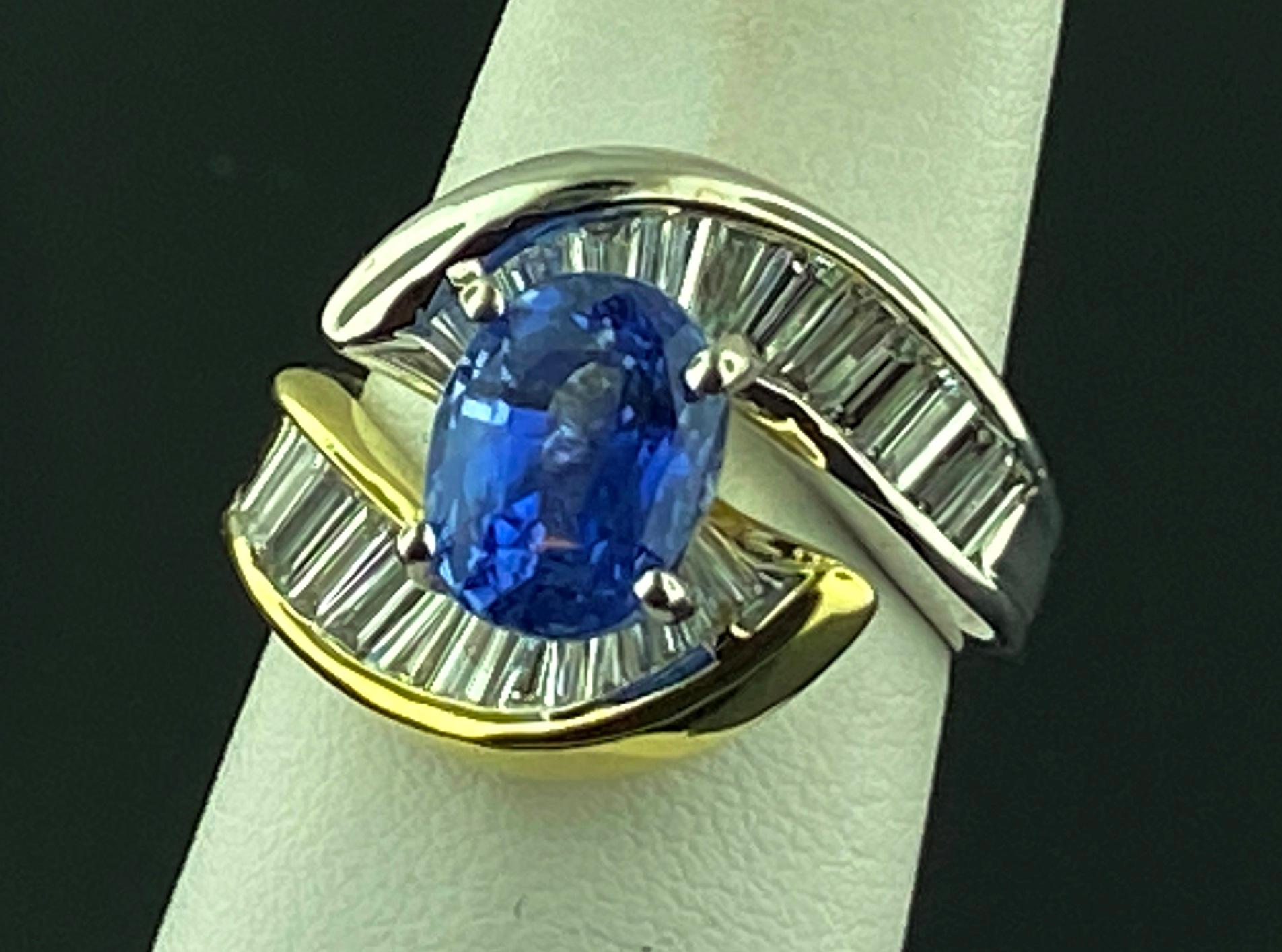 Set in an 18 karat white and yellow gold mounting, weighing 10 grams, in the center is a 4.03 carat Oval cut Blue Sapphire with 22 Baguette cut diamonds with a total diamond weight of 2.00 carats.  Color Range of F-G, Clarity of VVS.  Ring size is