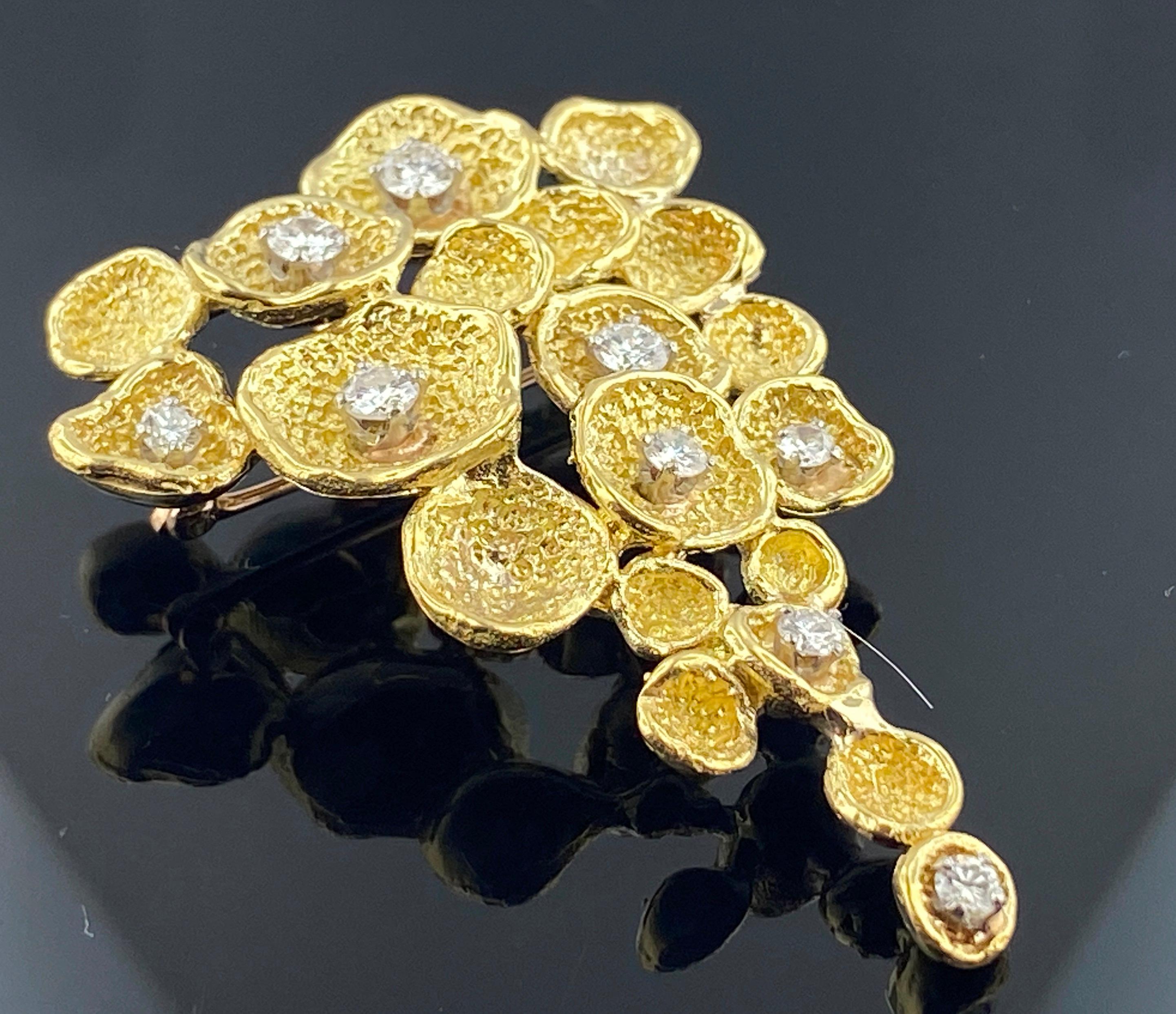 A multi-petal style brooch in 18 karat yellow gold with 9 round brilliant diamonds with a total diamond weight of 0.50 carats.  17 grams.