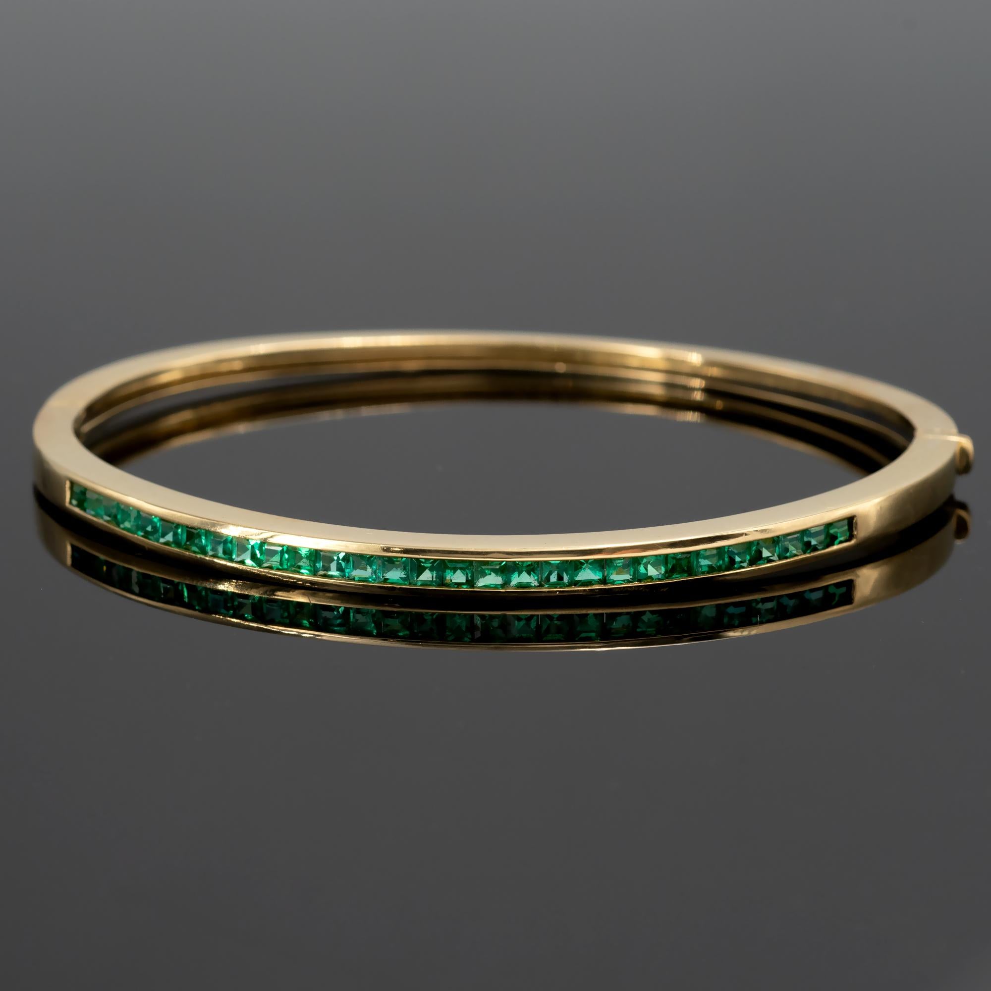 Bracelet à charnière en or jaune intemporel, serti d'une ligne d'émeraudes vivantes carrées. Un design parfait et iconique ! 
Or 18 carats avec émeraudes de 1,30 carat
Mesures intérieures : 58,2 x 48,7 mm (taille du poignet 16,5 cm)