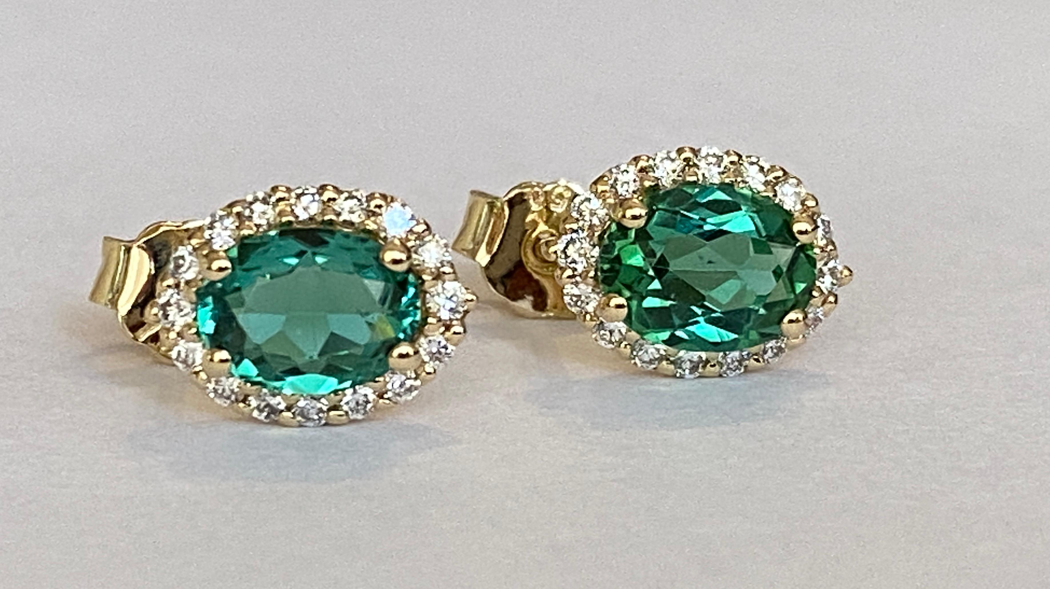 Offered in new condition, stud earrings in yellow gold, with two pieces of oval cut Green Tourmaline of approx. 2 carats together. The stones are surrounded by an entourage of 32 brilliant cut diamonds totaling approx. 0.40 ct of quality