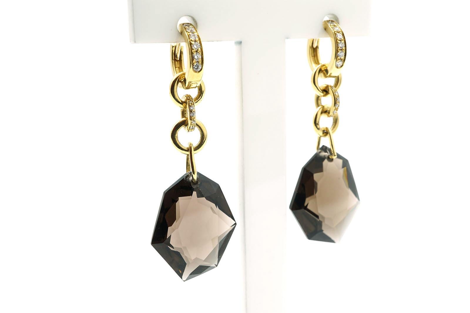 Chandelier earrings made in 18 Kt yellow gold, diamonds and two fume quartz. drops.
The drops has a bright irregular faceted cut.
These earrings has diamonds settled in the hoop part at the top and they can be worn in two different ways.
You can