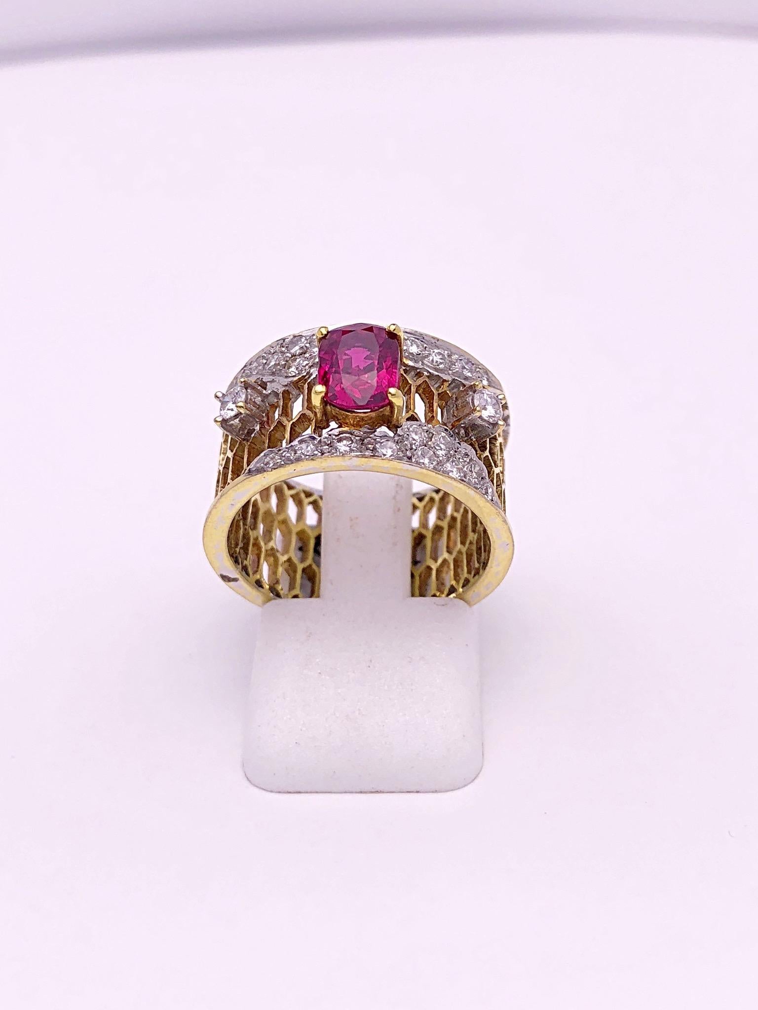This is a beautiful vintage 18 karat yellow gold band ring. The center oval Ruby weighs 1.33 carats. There is a single round brilliant Diamond on either side of the ruby, along with some smaller diamonds accenting the band. The entire ring is in a