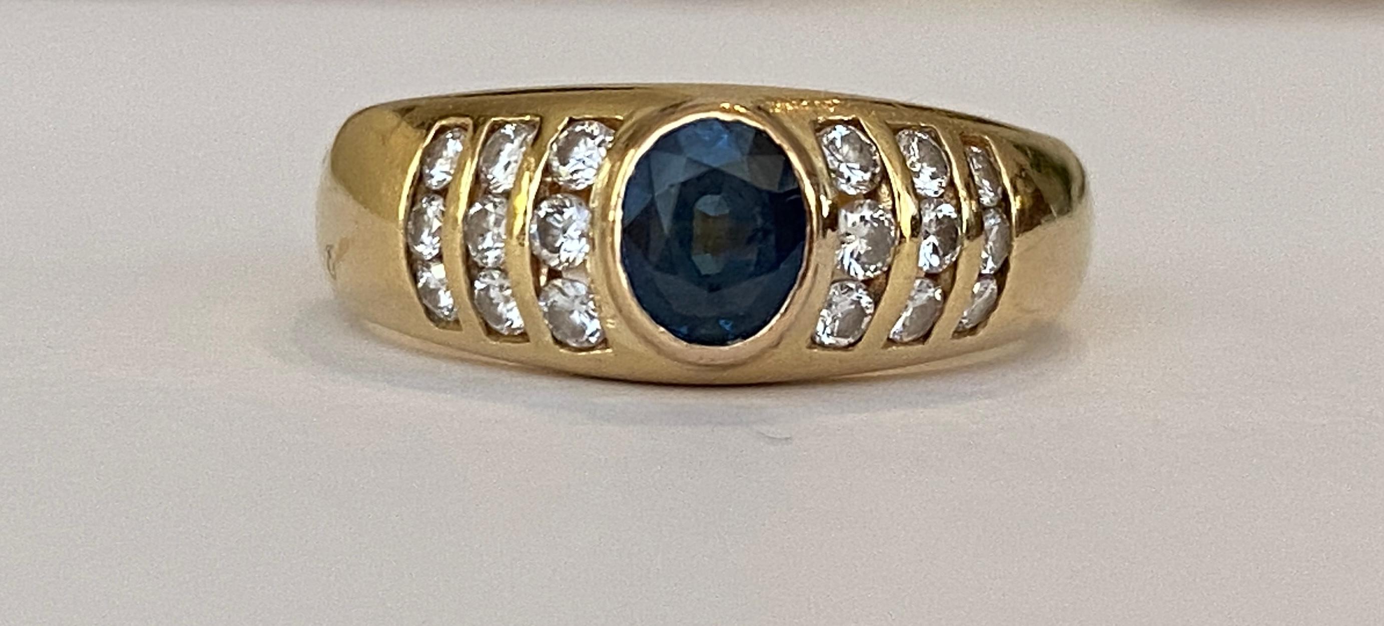 Angeboten wird ein Entourage-Ring aus 18 Karat Gelbgold, der in der Mitte mit 1 Stück eines natürlichen Saphirs im Ovalschliff von ca. 0,50 ct und mit 18 Diamanten im Brillantschliff von insgesamt ca. 0,36 ct in der Qualität G/VS besetzt