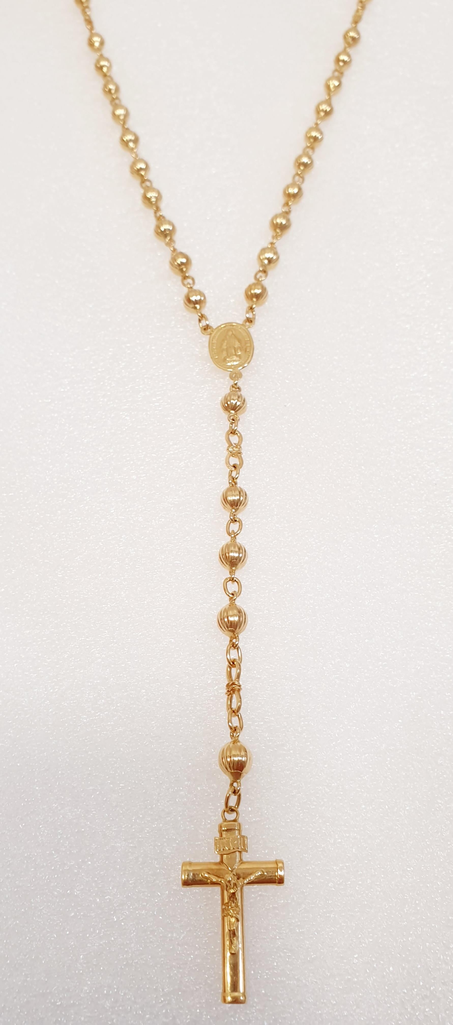 18 Kl Gold Rosary. with the  Virgin and cross with Christ.
4mm balls. Length to the medal: 70 cm. From the medal to the cross: 12 cm.
 It weight is 26,7 grams.

 All PRADERA jewels are guaranteed and come from sustainable and reliable sources and