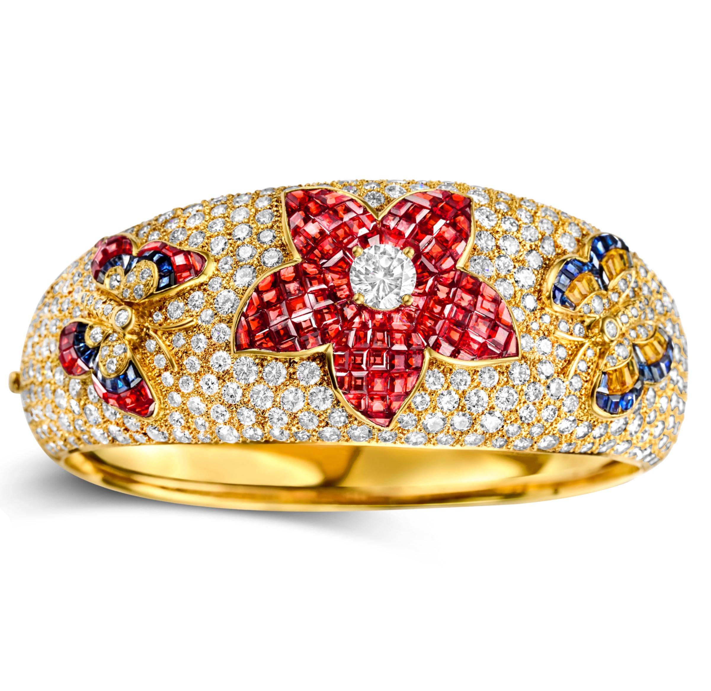 Magnificent 18 kt. Yellow Gold Wide Bangle Bracelet With Diamonds, Rubies, Blue & Yellow Sapphires.

One of A Kind !

Diamonds: Brilliant cut diamonds together 17.86 ct.

Ruby: Square cut rubies, together 7.92 ct.

Blue Sapphire: sapphires together