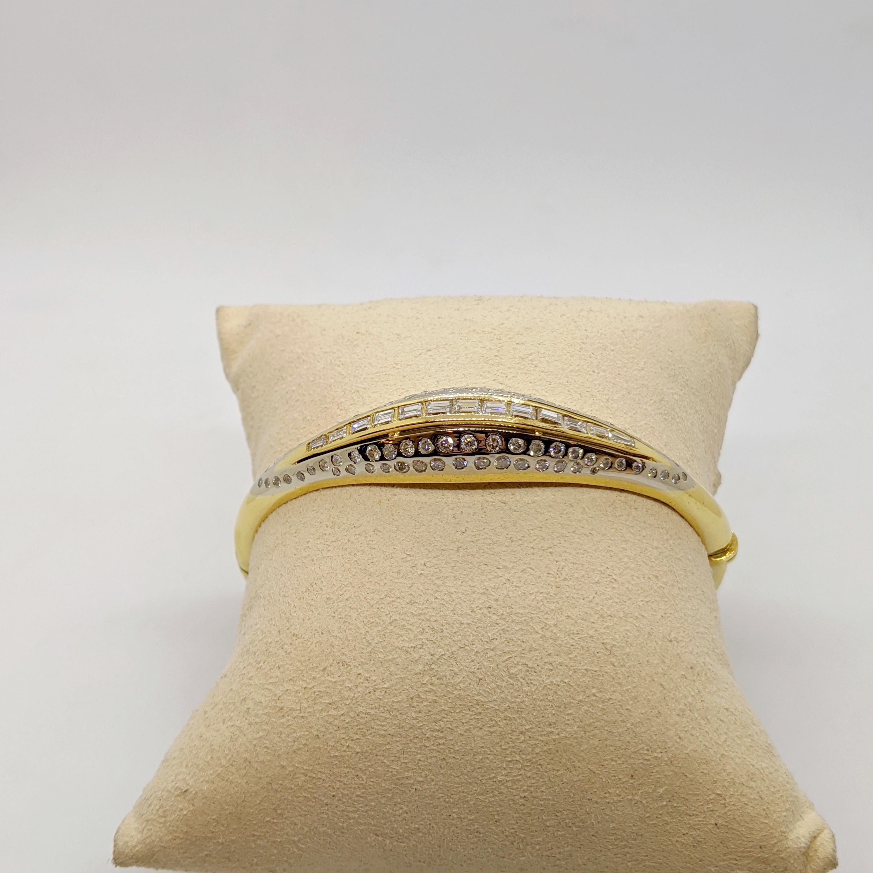 A beautiful and very easy to wear Diamond bangle bracelet. 
This bracelet is designed in 18 karat yellow gold. The top half of the bracelet is bombe'. It has round brilliant cut Diamonds sprinkled into an 18 karat white gold section. The middle