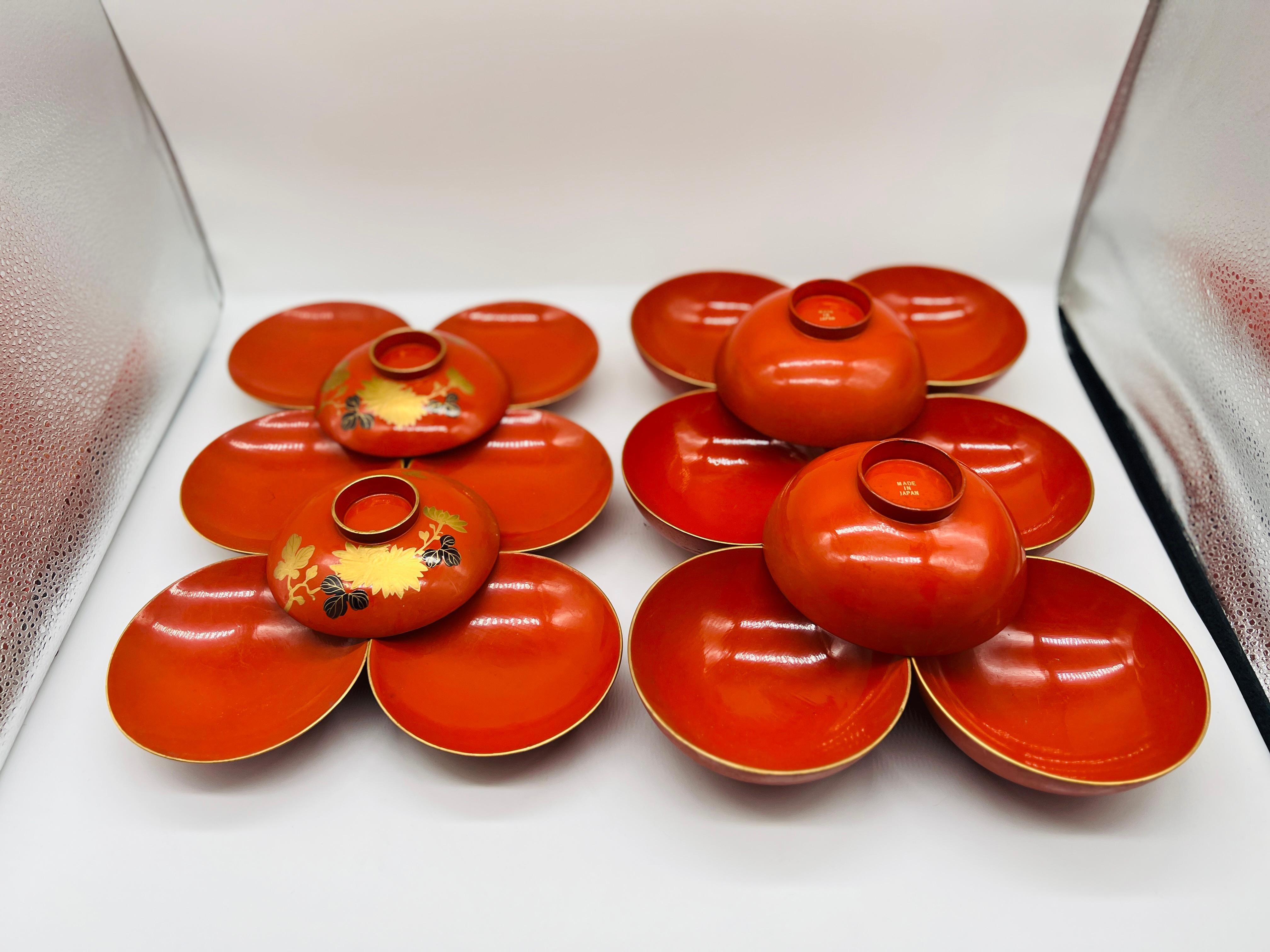 Questo bellissimo set di ciotole per il riso in lacca giapponese vintage da 18 pezzi comprende nove set coordinati, ciascuno composto da ciotola e coperchio. Ogni pezzo è impreziosito da dettagli floreali e fogliati dorati a mano, accentuati da un