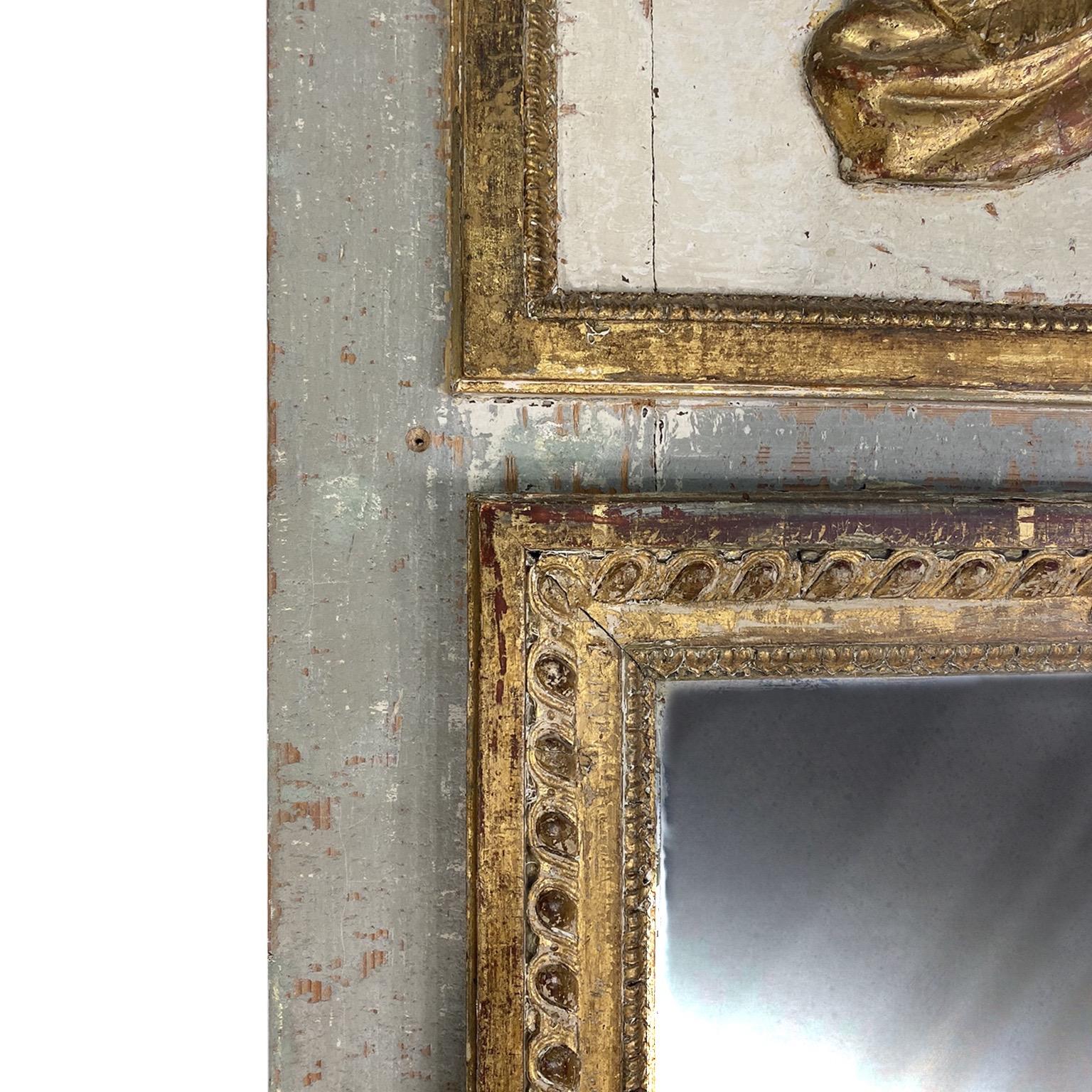 Beautiful 18th century French Louis XVI painted and gilded wooden trumeau mirror with face of Roman soldier. This mirror is all original paint and gilt. It could be a wall mirror or a floor mirror. Lovely patina and crazing on paint.