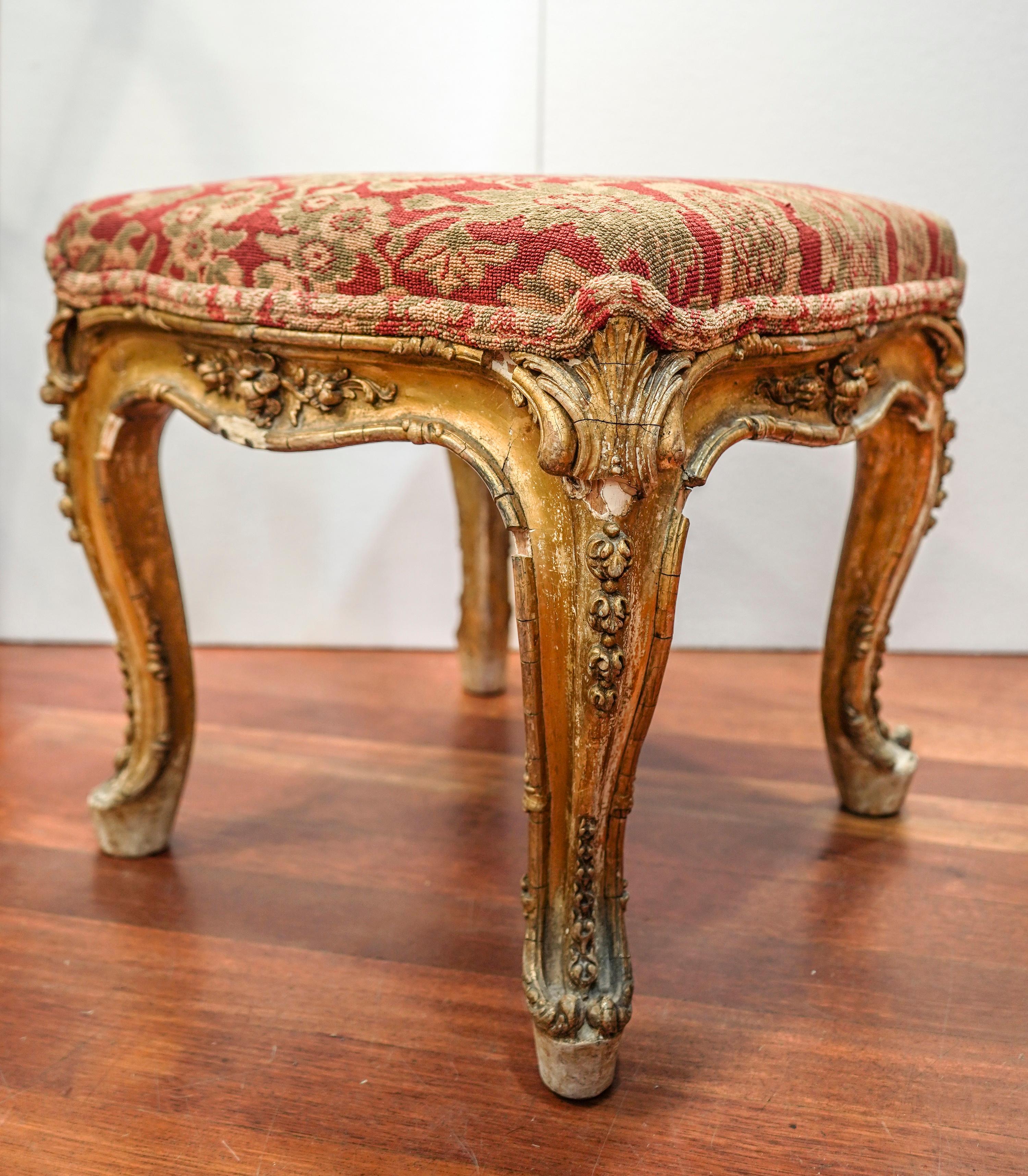 Delicious and exquisite French Louis XV carved and golded wood footstool, with cabriole legs and floral motif as wood carving. Overlaid with red damask drawing fabric.
It has some lights looses but it has a lot of character and patina.
It comes