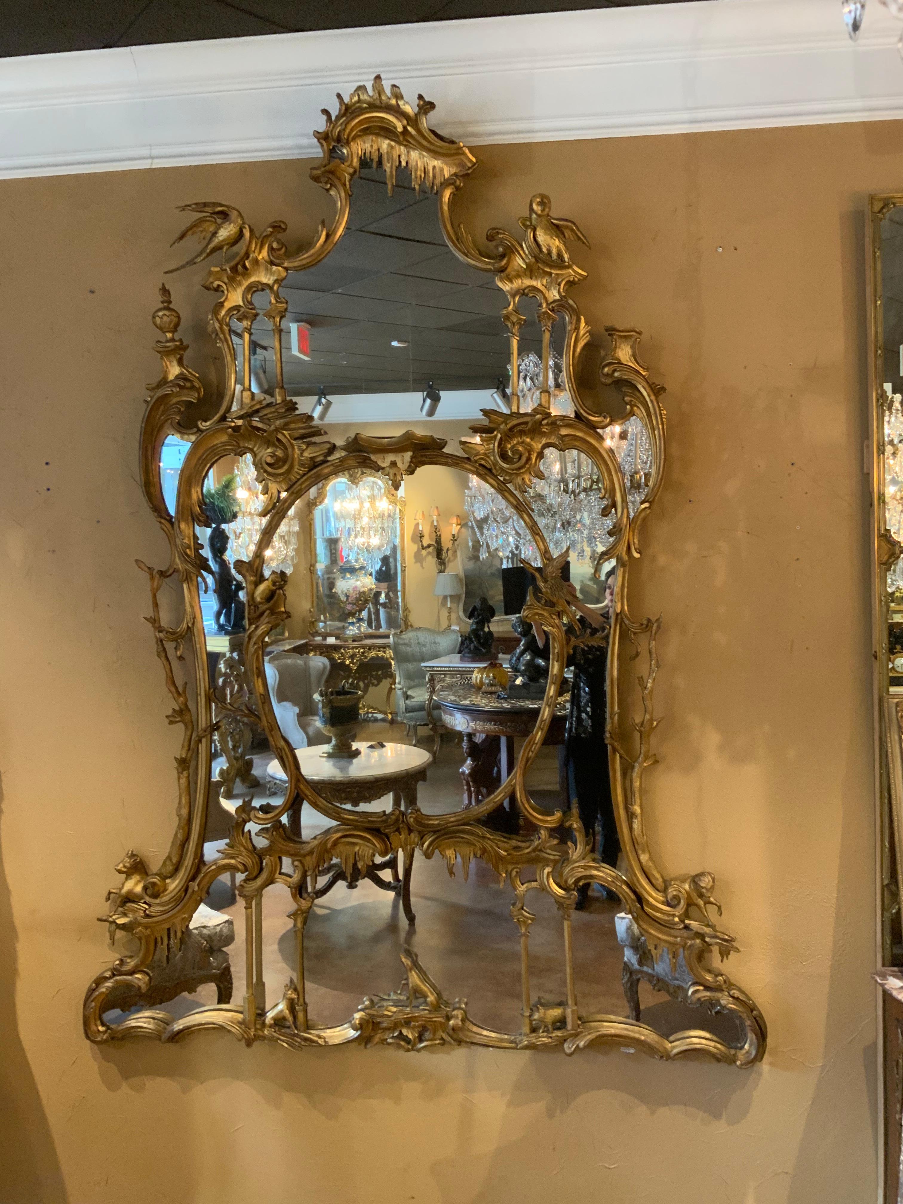 Palace size fine and rare gilt-wood mirror after a design by Thomas Johnson .
Circa 1750-1780’s chippendale mirror. Having finely carved hoho bird 
And Other animals positioned around the perimeter. Soft antique
Gold patina surrounds the entirety.