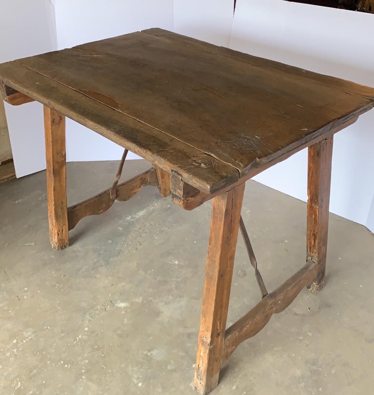 This is an early walnut Spanish table that could be a great small desk or side table. It has a warm honey patina and its stability is good. You can see in the photos the dovetail construction.
The stretcher has been changed at some point.