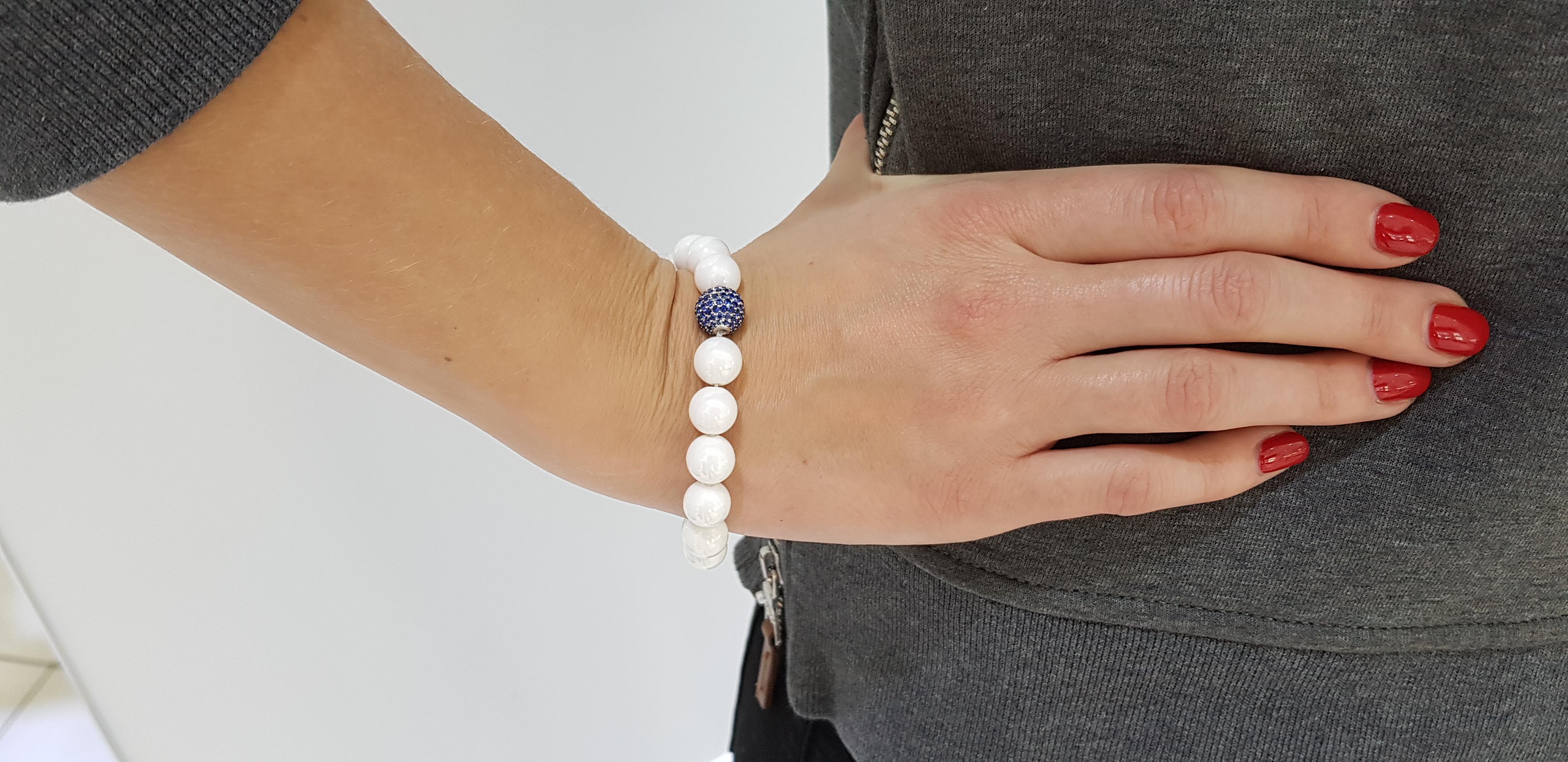 The Original Tresor Paris Bracelet features one Sphere with 1.80 Carat Pave set Blue Sapphire as a focal point. Set in 18 Karat White Gold and has 16 ceramic beads as well as one 18 Karat White gold bead clasp. Size will fit all from 7.00 to 8.00