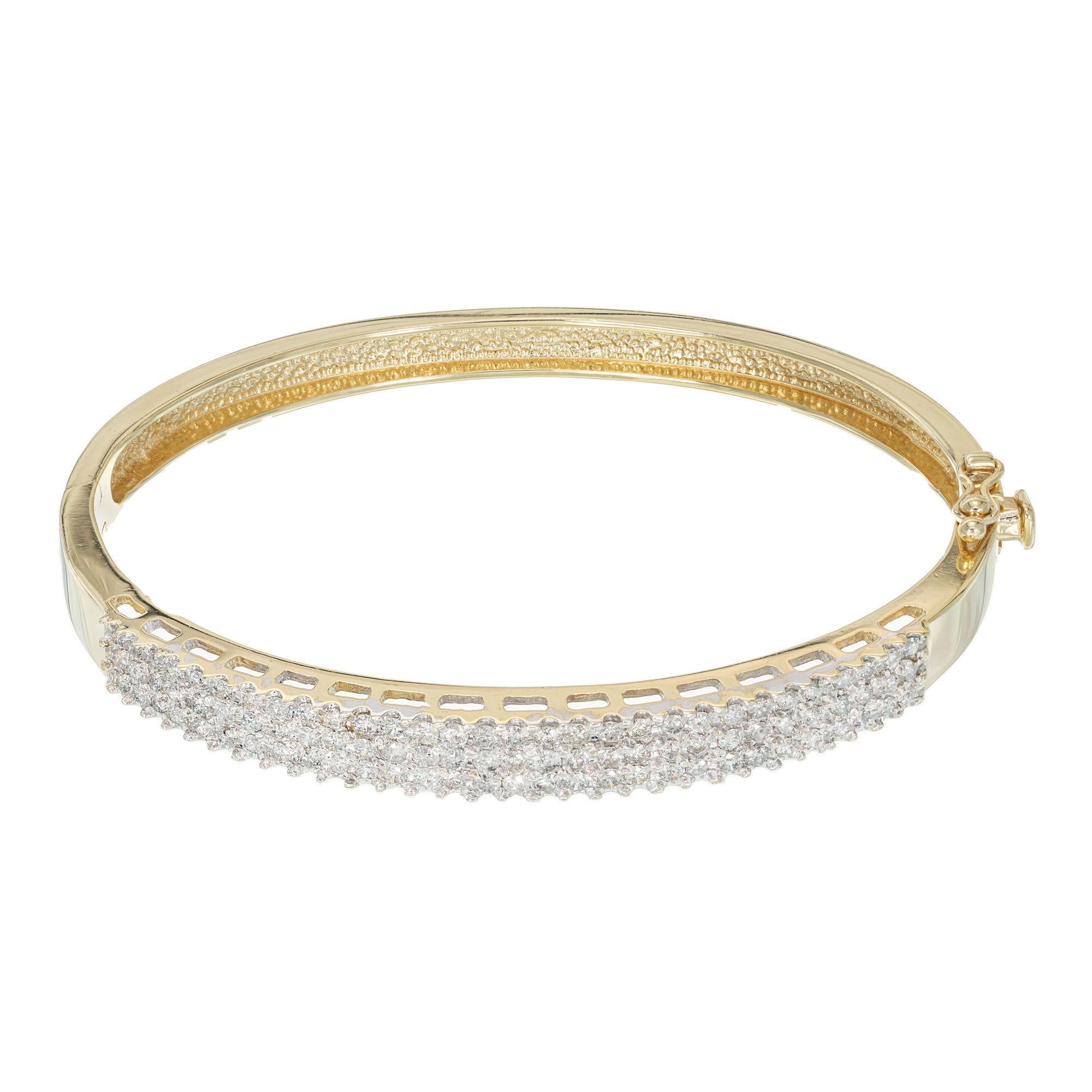 bracelet bangle à trois rangs de diamants des années 1970. Le haut en or blanc est serti de 90 diamants taille ronde et serti dans un bracelet en or jaune 14k. Fermeture cachée et sécurité latérale. poignet de 7-7 1/2 pouces. 

90 diamants ronds