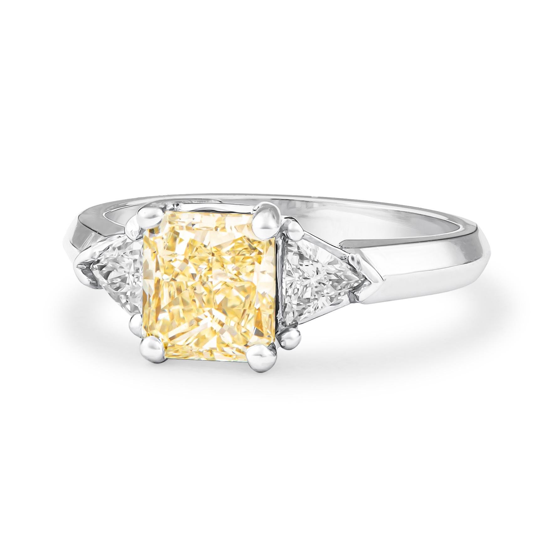 Captivating 3-stone diamond ring designed in 18K white gold that features one 1.80 carat total radiant diamond (Y-Z color, SI2 clarity) and 0.41 carats in two perfectly matched trillion diamonds. The ring was crafted in a size 7 and may be resized