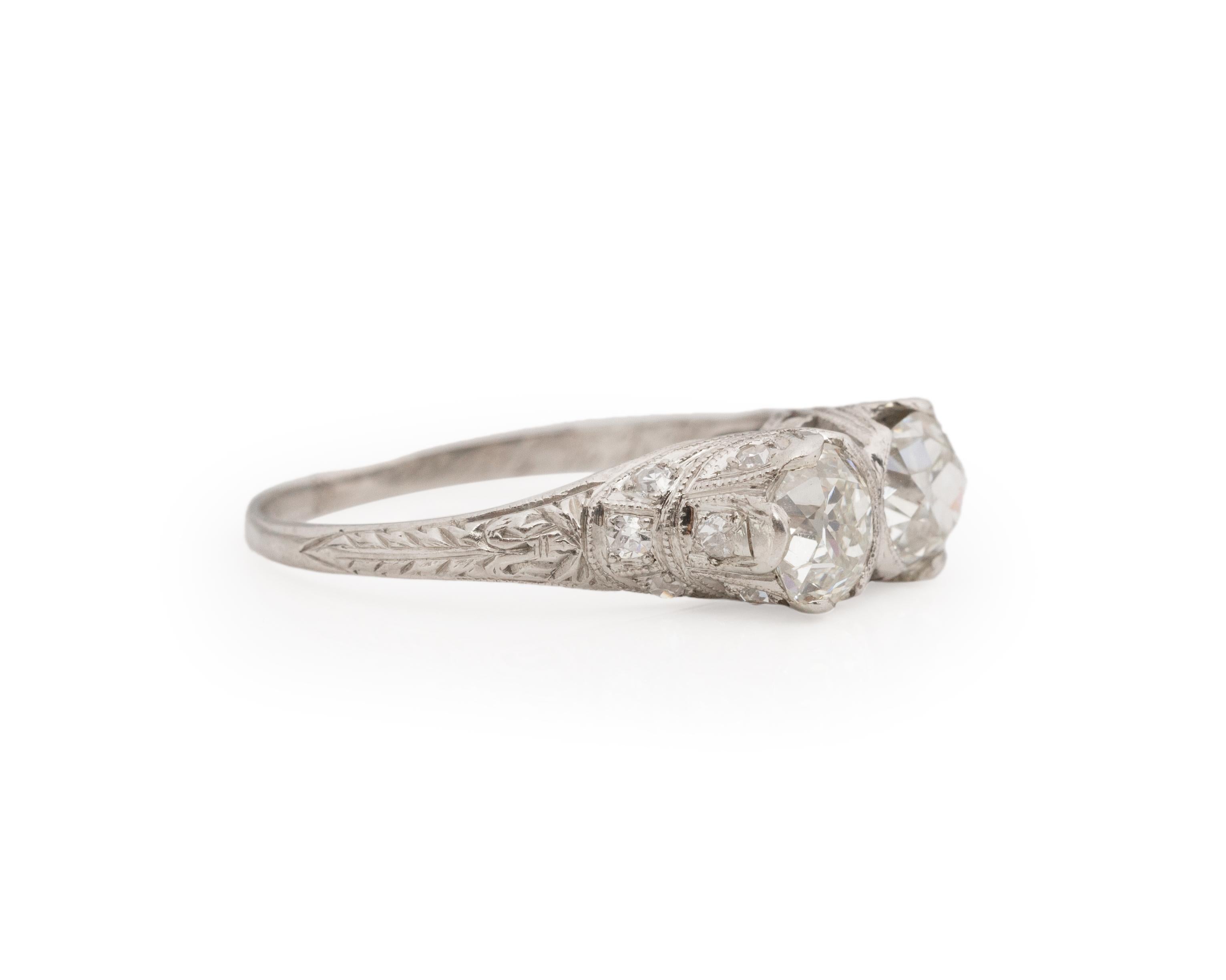 Year: 1920s

Item Details:
Ring Size: 7.75
Metal Type: Platinum [Hallmarked, and Tested]
Weight: 3.6 grams

Main Two Diamond Details:
Weight: 1.80ct total weight, each main stone is .90ct.
Cut: Old Mine Brilliant
Color: H/I
Clarity: VS
Type: