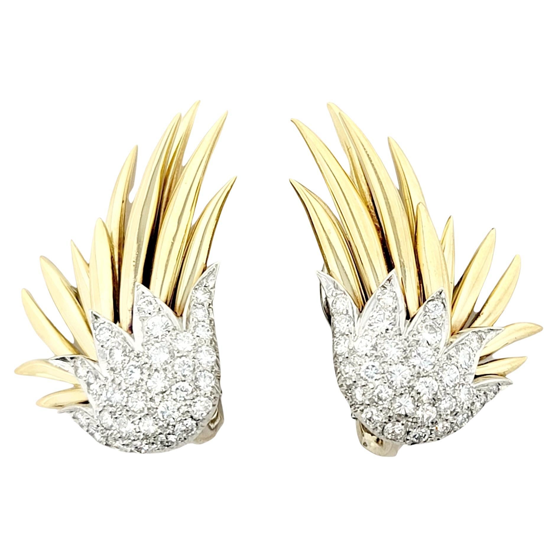 Absolutely breathtaking diamond and 18 karat gold spray earrings. This stunning pair features icy white pave diamonds set in white gold and polished yellow gold spikes bursting off the lobe in an elegant spray design.  They are a fabulous statement