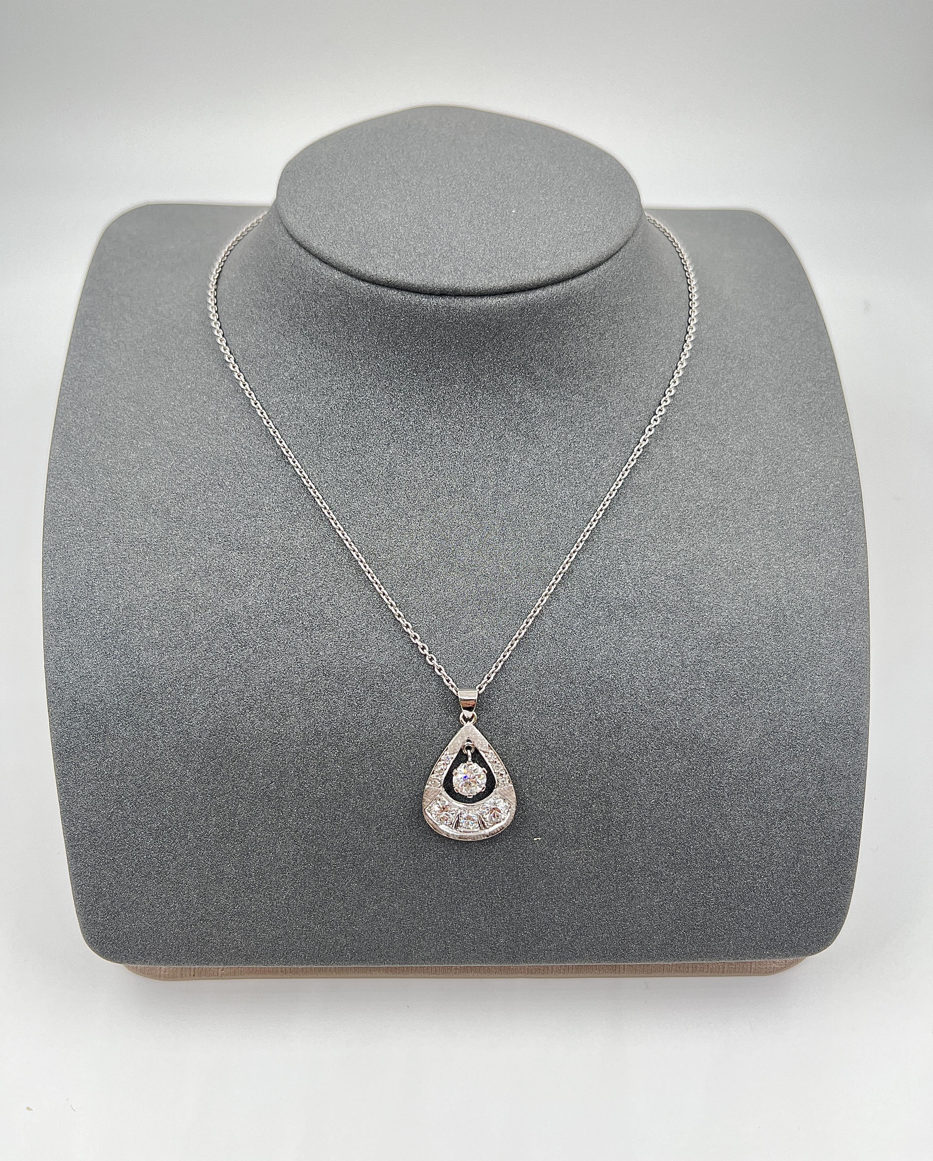 Questa collana con ciondolo presenta un design accattivante con un mix di diamanti. Il centro, che è un taglio antico, è un diamante bianco rotondo da 0,80 carati, con una purezza leggermente inclusa SI1/SI2 e un colore di classe I/J. Intorno ad