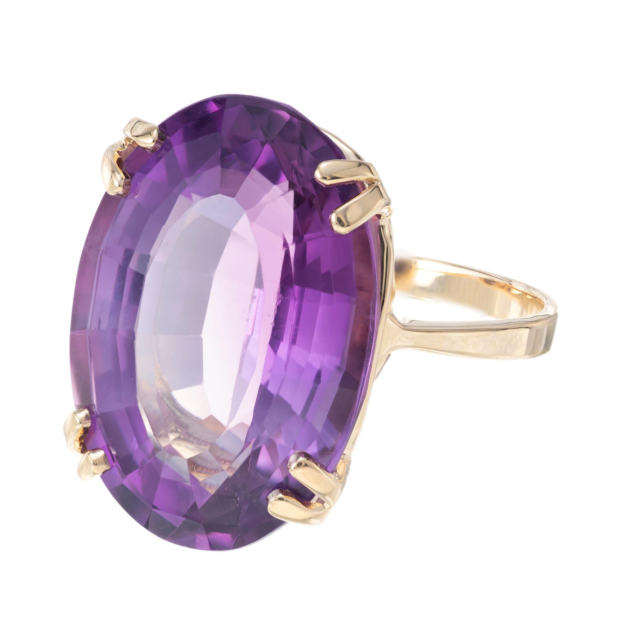 Mid- Century Amethyst cocktail ring. 18.00 carat oval amethyst in a simply double 4 prong 14k yellow gold setting.  Circa 1950's.

1 oval purple amethyst, approx. 18.00cts
Size 7 and sizable
14k yellow gold 
Stamped: 14k
7.2 grams
Width at top: