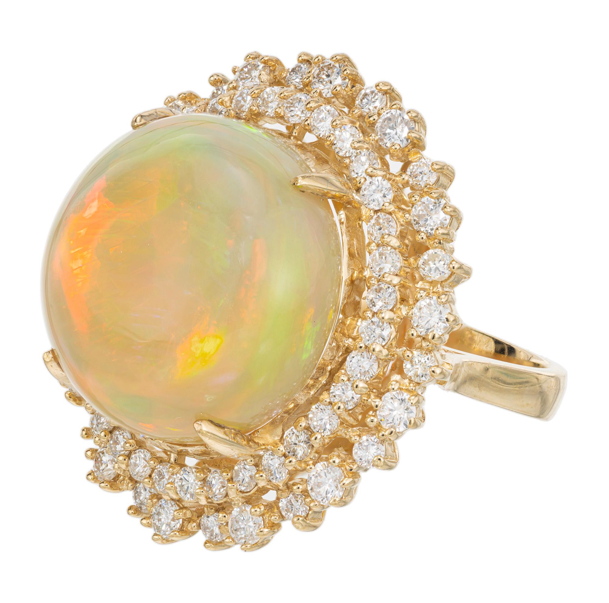 Amazing Ethiopian opal and diamond ring. Spectacular 17 millimeter round high dome cabochon of approximately 18.00 carats, sits in a 14k yellow gold setting with a double halo of round brilliant cut diamonds that approximately total 1.25cts. This