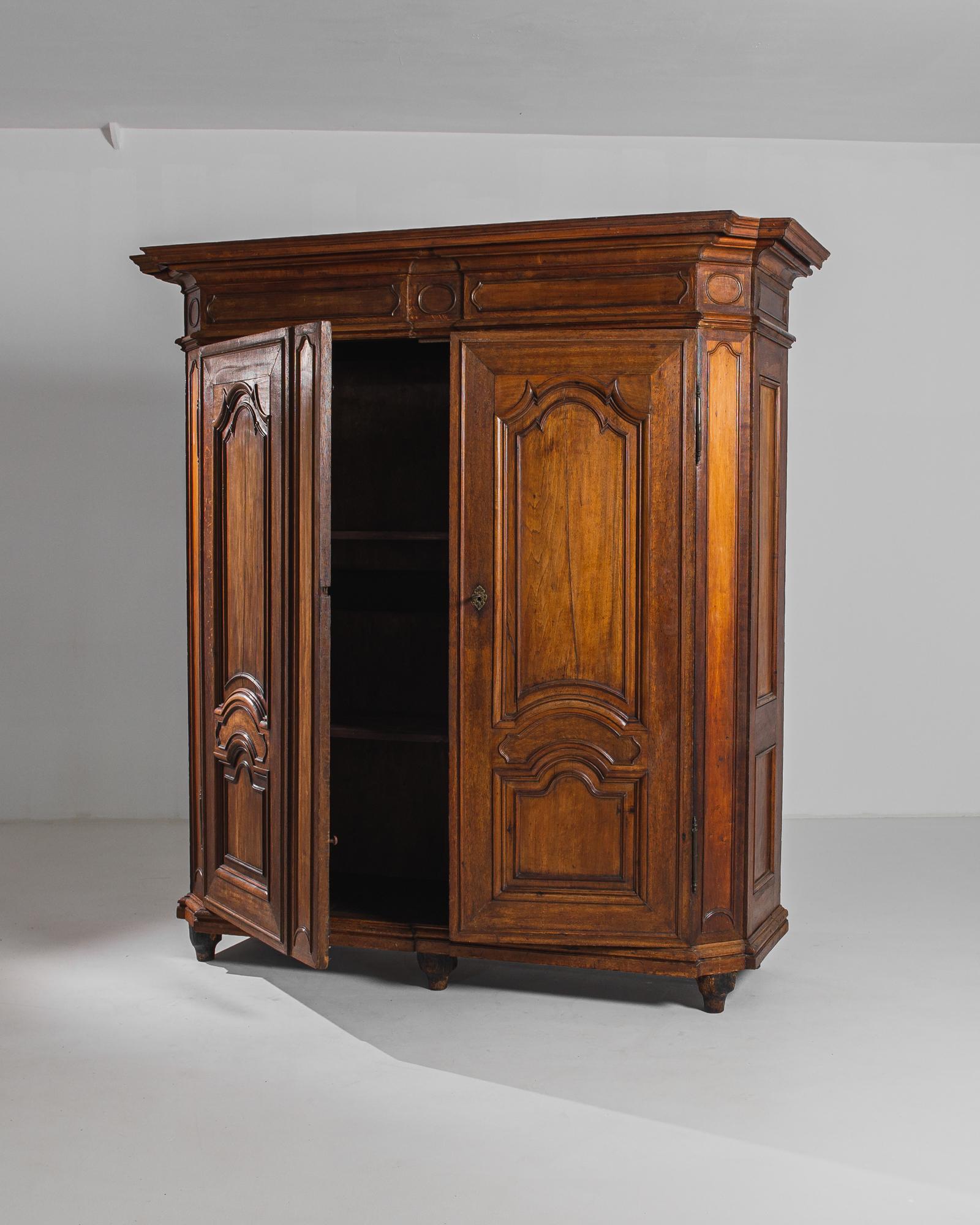 From the distinguished halls of 19th-century Europe emerges this exquisite wooden armoire, adorned with its original patina that speaks volumes of its rich history and enduring elegance. Crafted with precision and artistry, this armoire stands as a
