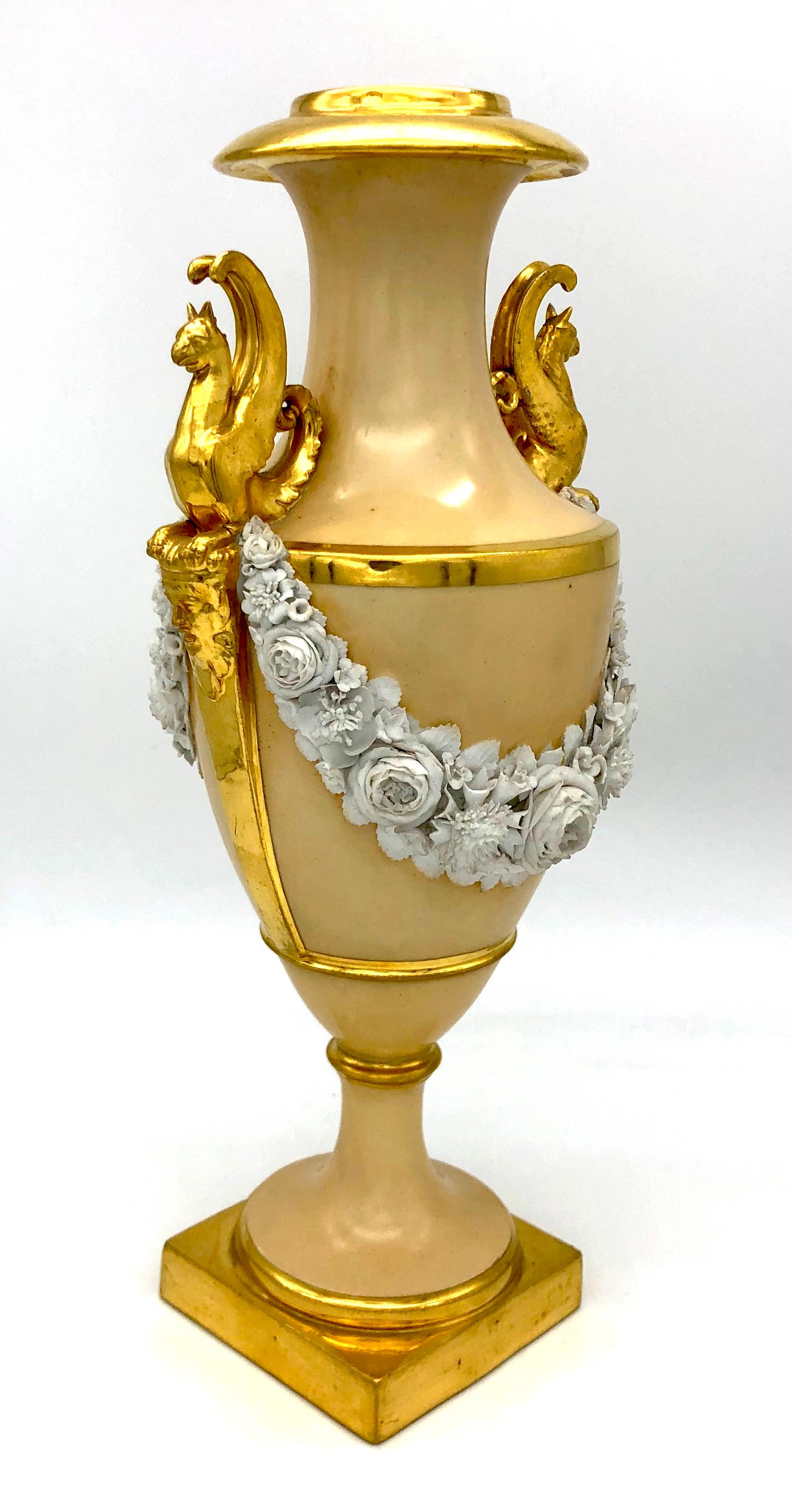 This very high quality French vase in caramel hue with guilding is most probably made by the Nast Porcelain Manufacture ( 1754 - 1817 ). It's handles are designed in the shape of two gilt griffins who rest their paws on young men's faces. The vase