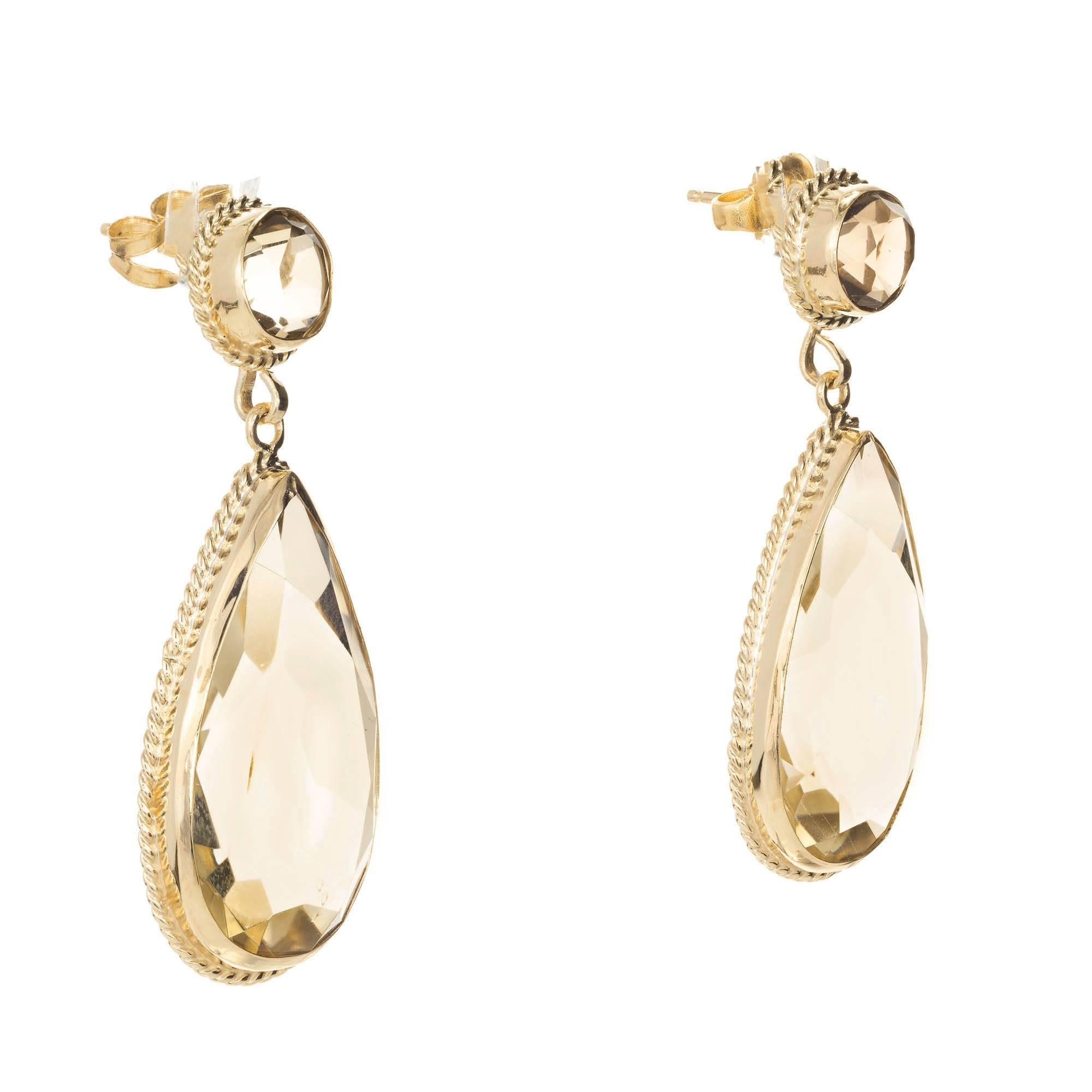 1950s 14k yellow gold smoky Quartz dangle earrings.

2 round grayish brown smoky Quartz, approx. total weight 2.00cts, VS
2 grayish brown pear shaped smoky Quartz, approx. total weight 16.00ct, VS
14k Yellow Gold
10.0 grams
Tested and stamped: